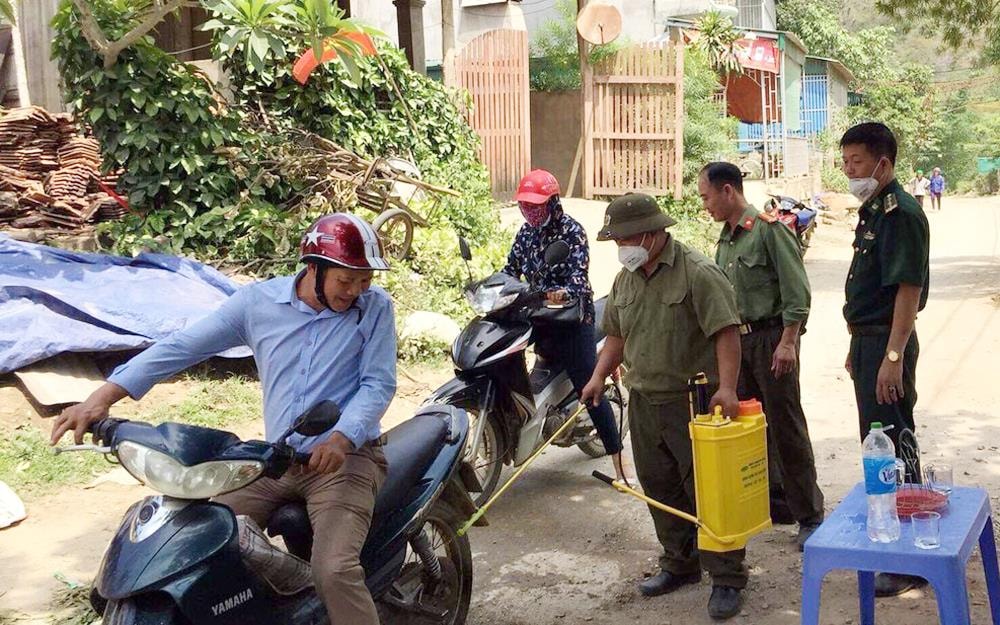 Chốt liên ngành tại xã Tà Cạ, huyện Kỳ Sơn phun thuốc khử trùng phương tiện qua lại. Ảnh: Phương Linh