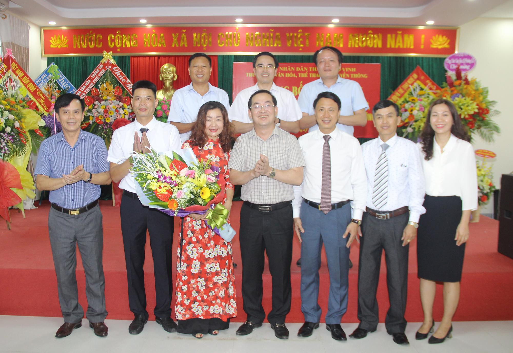 Lãnh đạo thành phố tăng hoa chức mừng Ban Giám đốc Trung tâm Văn hóa, Thể thao và Truyền thông thành phố Vinh. Ảnh: Minh Chi