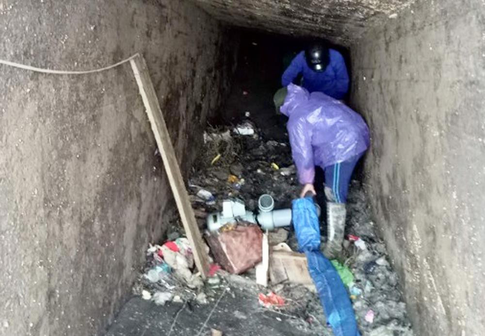 Dọn rác trong lòng cống lấy nước ở Quỳnh Thạch. Ảnh: Văn Trường