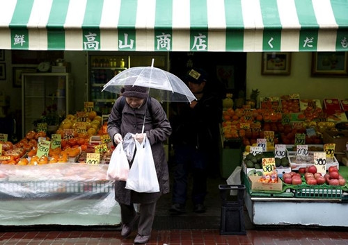Một phụ nữ mua trái cây đựng trong túi nhựa miễn phí tại cửa hàng ở Tokyo. Ảnh: Reuters.