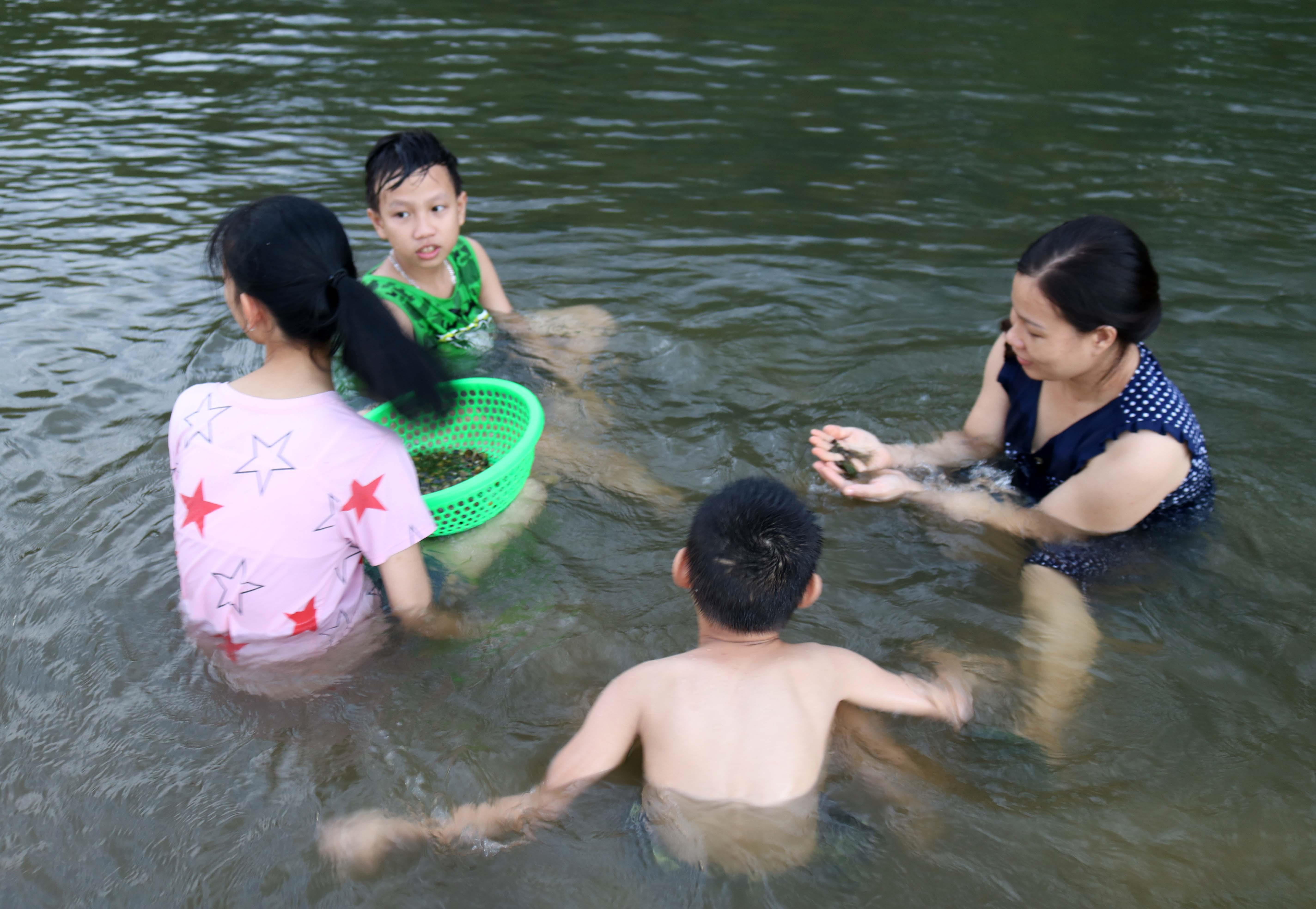Nhiều gia đình đi bắt hến cả nhà, quầy quần giữa sông khá vui vẻ.