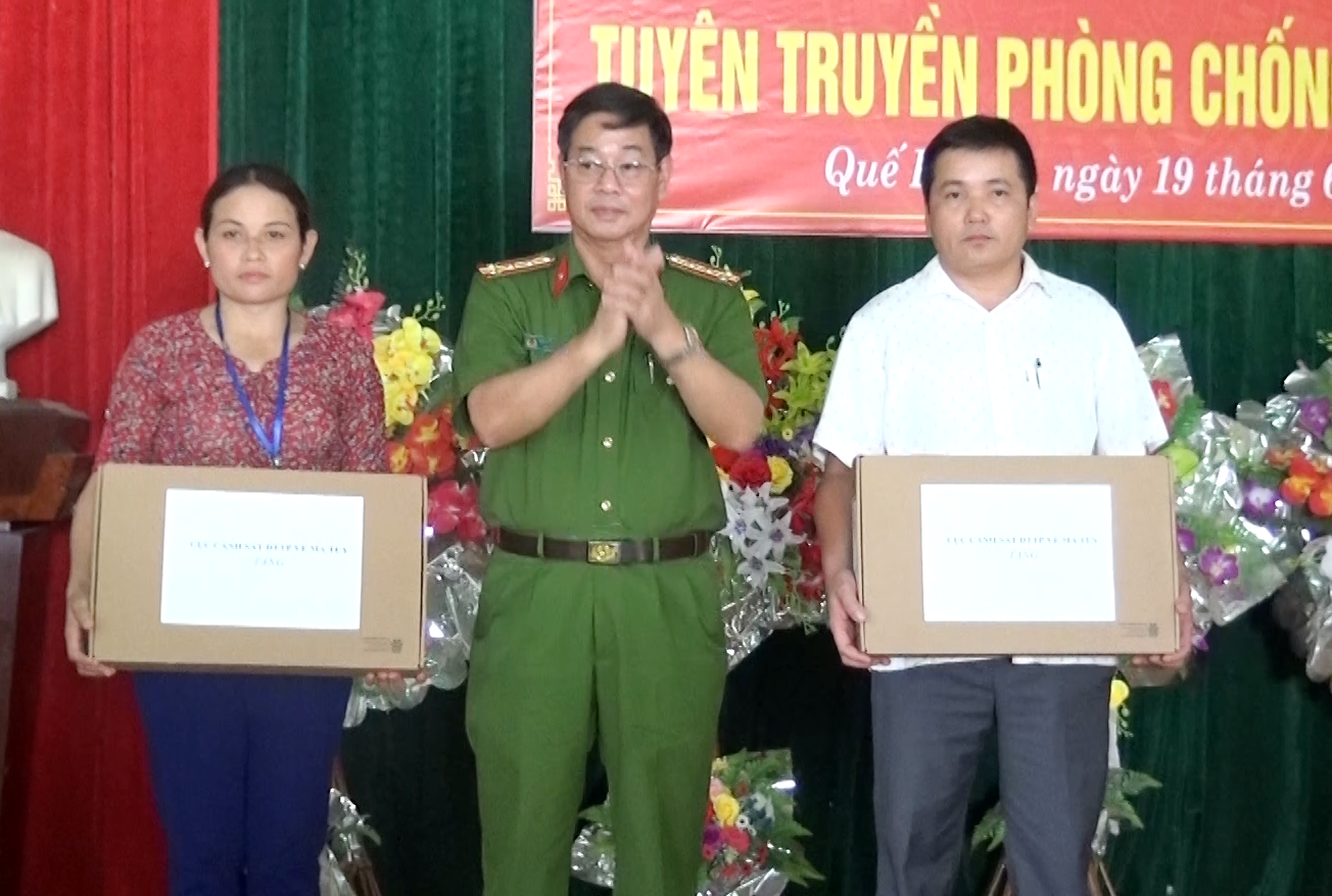 Đại tá Nguyễn Địch Nam - Phó Cục trưởng Cục CSĐT tội phạm về ma túy trao tặng 2 chiếc máy vi tính cho UBND xã Thông Thụ. Ảnh: Ngọc Tăng