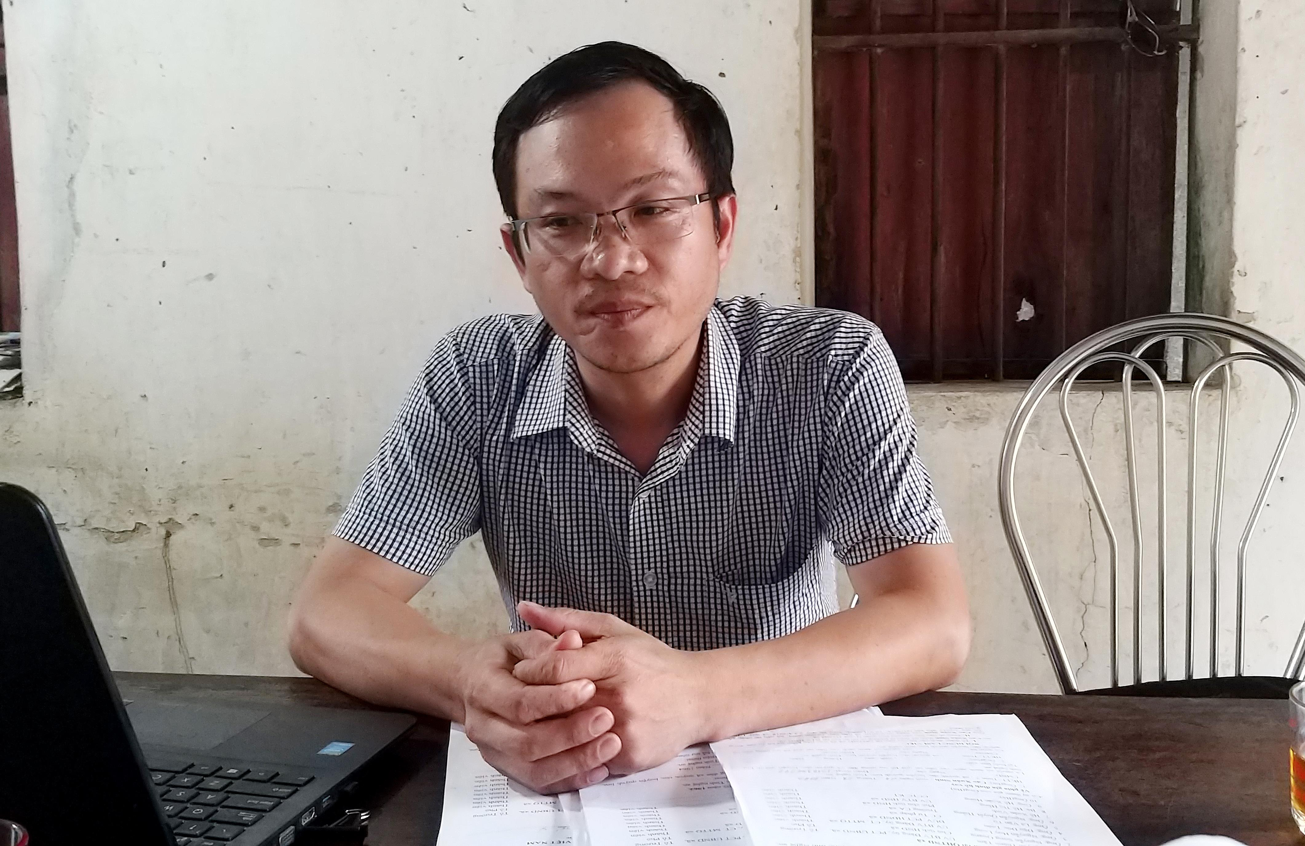 Ông Nguyễn Song Quang - Chủ tịch Hội nông dân xã Quỳnh Tân trao đổi về những khó khăn trong việc thu hồi số dư nợ cho vay. Ảnh: Phạm Bằng