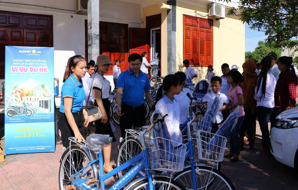 Cán bộ và nhân viên Công ty Bảo Việt Nhân thọ Bắc Nghệ An trao tận tay xe đạp cho các học sinh. Ảnh: Nguyễn Hải