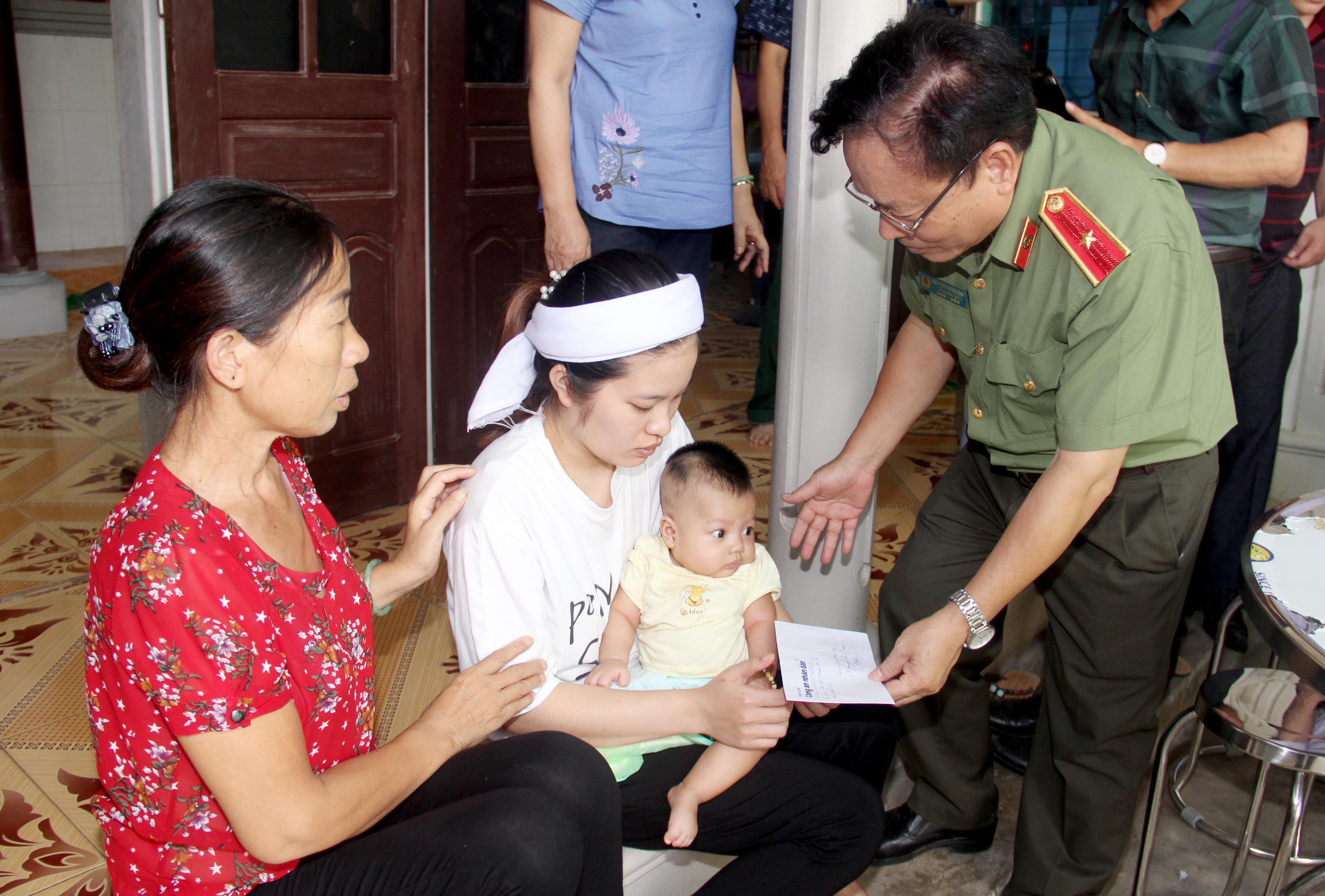 Thiếu tướng Nguyễn Hồng Thái trao món quà động viên cho thân gia anh Nguyễn Văn Mạnh. Hiện anh Mạnh vẫn đang mất tích, trong khi đứa con đầu lòng của anh Mạnh mới sinh được 3 tháng. Ảnh: Phạm Bằng