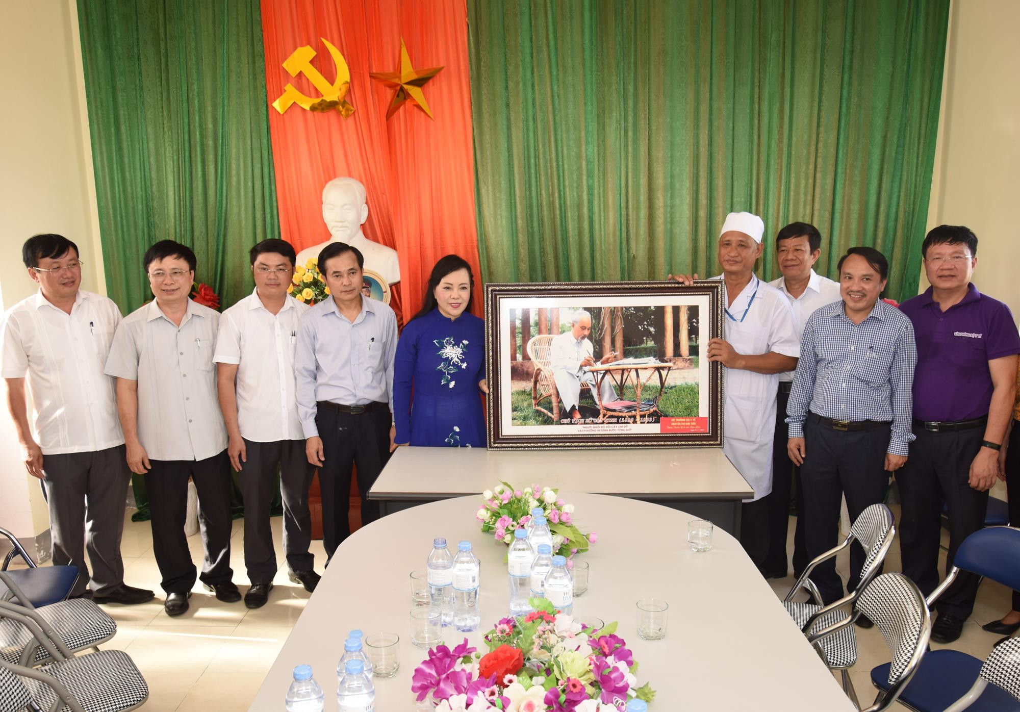 Bộ trưởng Bộ Y tế tặng bức tranh Chủ tịch Hồ Chí Minh cho trạm y tế xã Kim Liên. Ảnh: Từ Thành