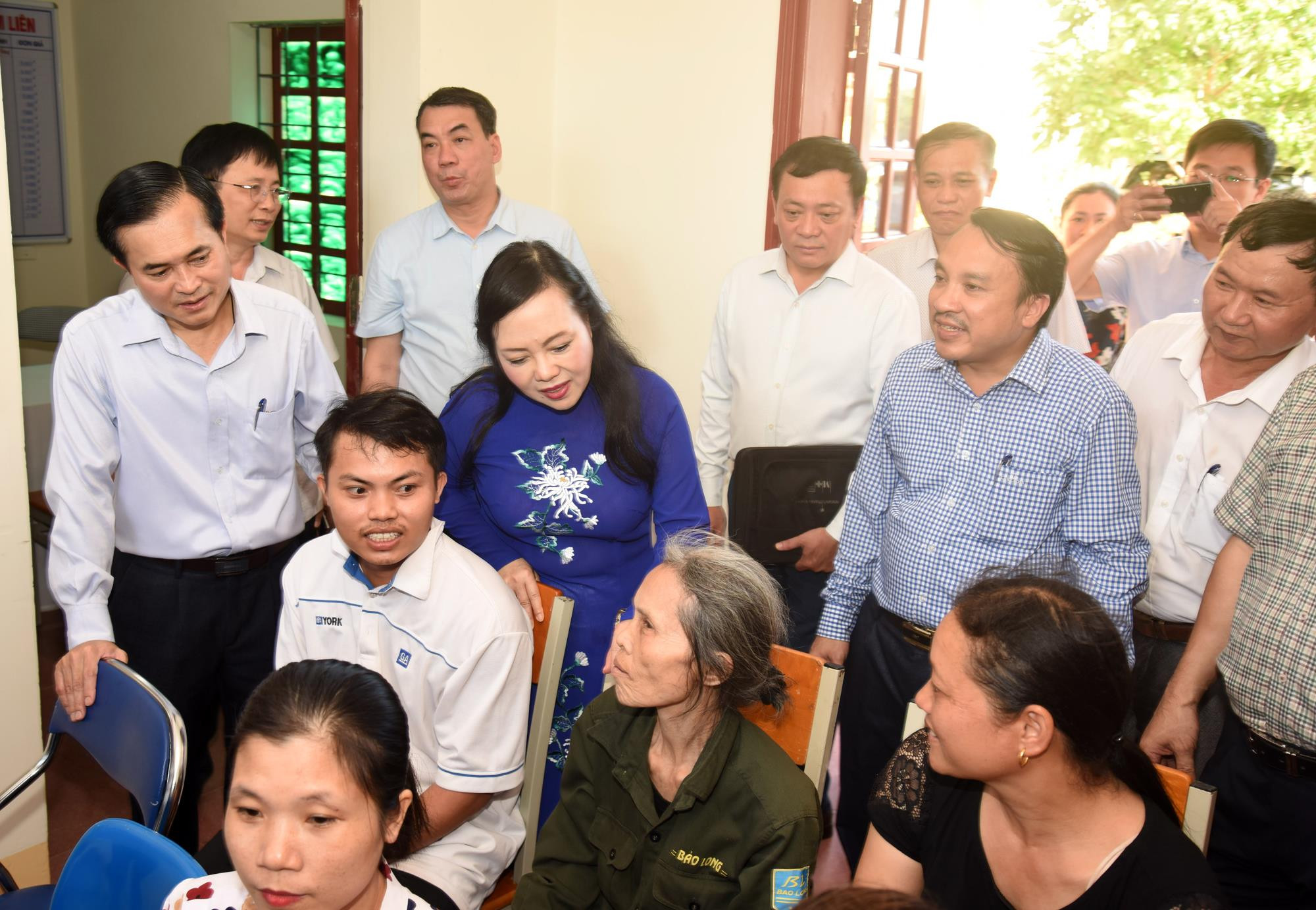 Bộ trưởng Nguyễn Thị Kim Tiến trao đổi cùng người dân đến khám chữa bệnh tại trạm y tế xã. Ảnh: Từ Thành