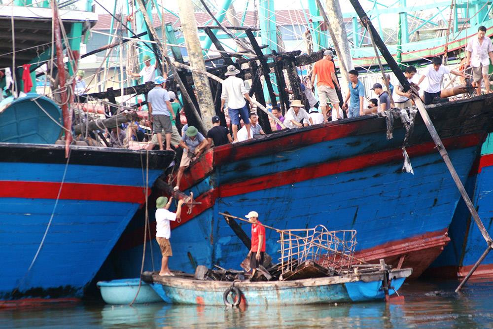 Ngư dân trên tàu cá bị cháy ở xã Quỳnh Nghĩa (Quỳnh Lưu) đang tập trung khắc phục. Ảnh: Việt Hùng