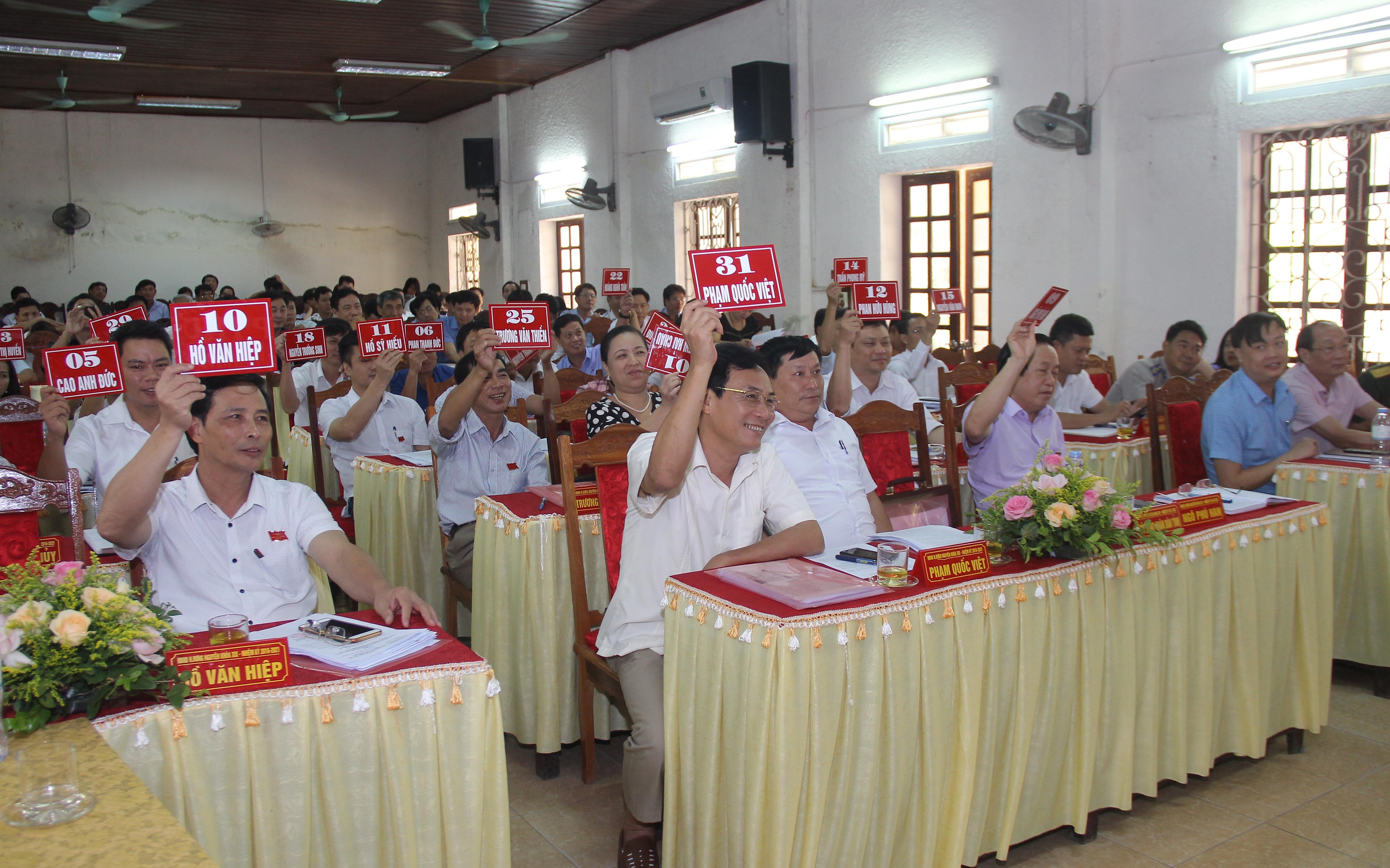 Các đại biểu thông qua nghị quyết xác nhận kết quả bầu bổ sung Ủy viên UBND huyện, nhiệm kỳ 2016 - 2021. Ảnh: Mai Hoa