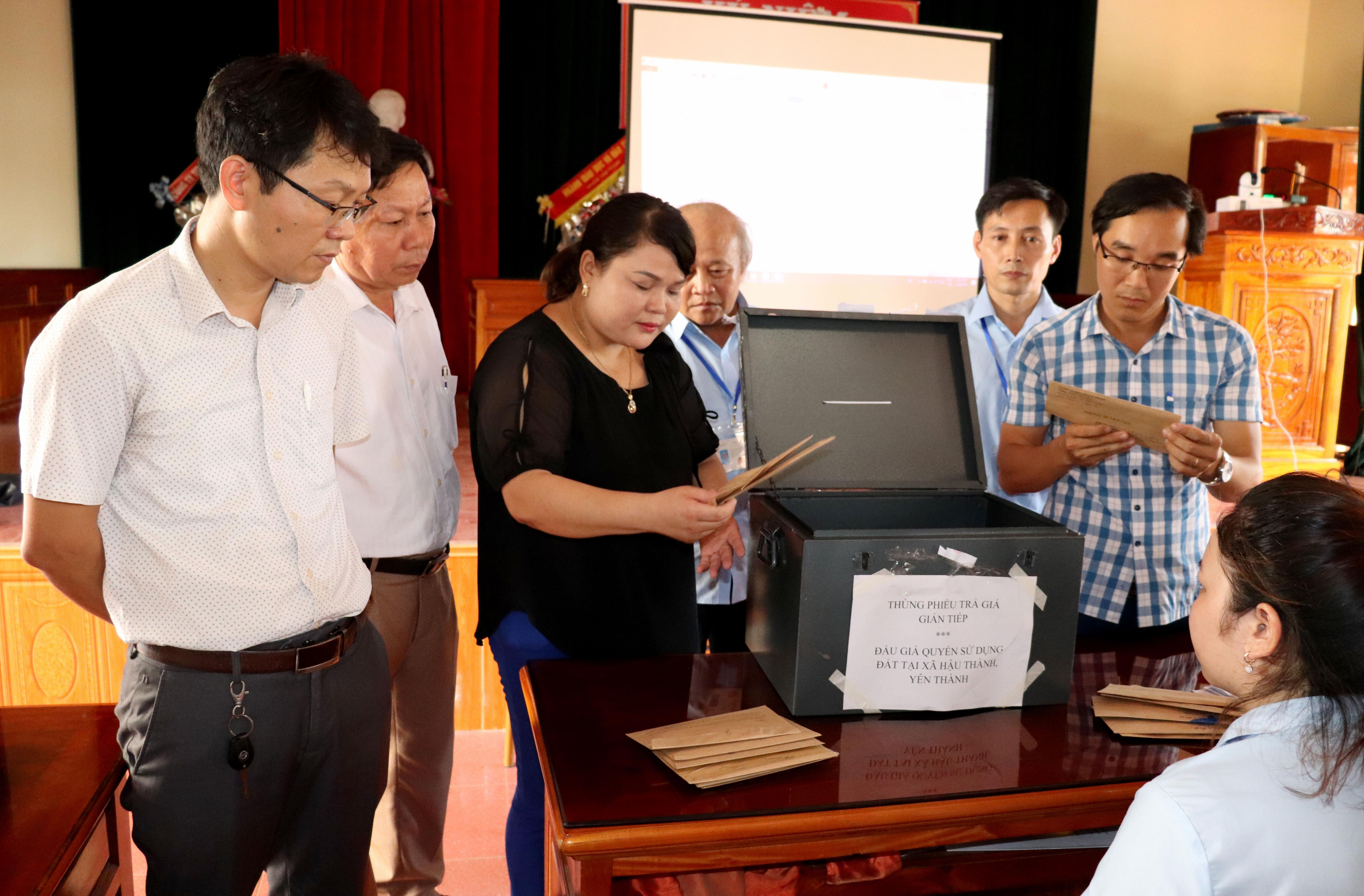 Khách hàng kiểm tra niêm phong thùng phiếu và niêm phong phong bì sau khi thùng phiếu được mở. Ảnh: Thái Dương