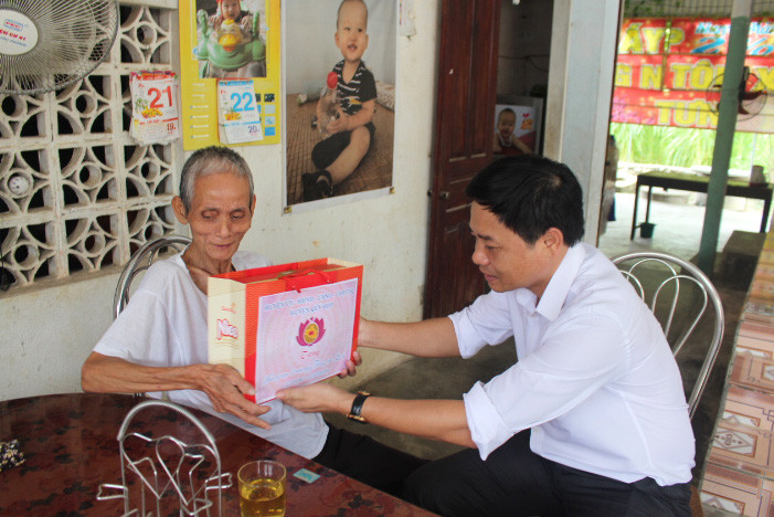 Đồng chí Hồ Lê Ngọc, bí thư huyện ủy Quỳ Hợp tặng quà cho bệnh binh Dương Công Phượng xã Châu Quang