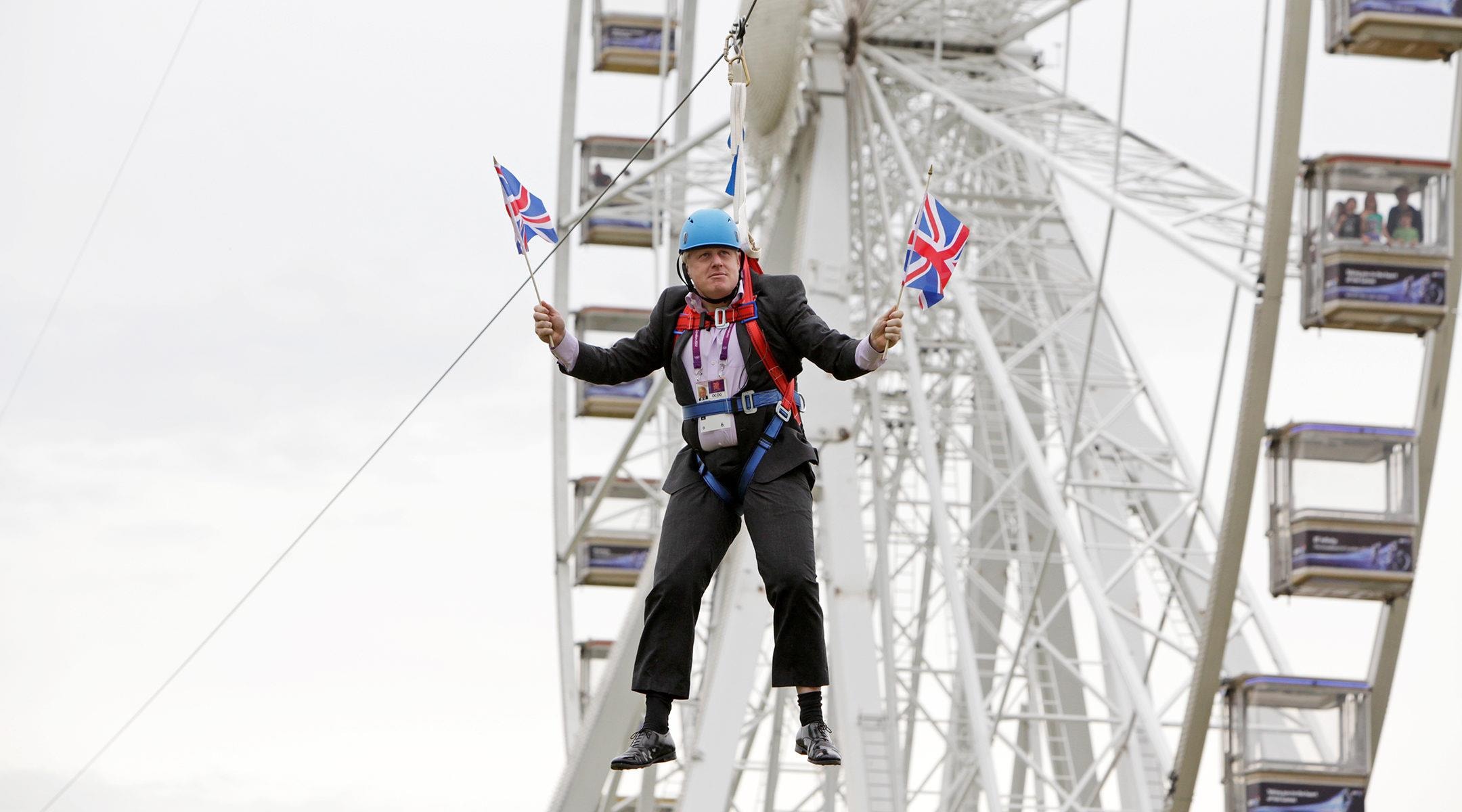 Ông Boris Johnson có hành động “kỳ quặc” treo mình trên dây kéo để cổ vũ Olympic London năm 2012. Ảnh: Barcroft Media