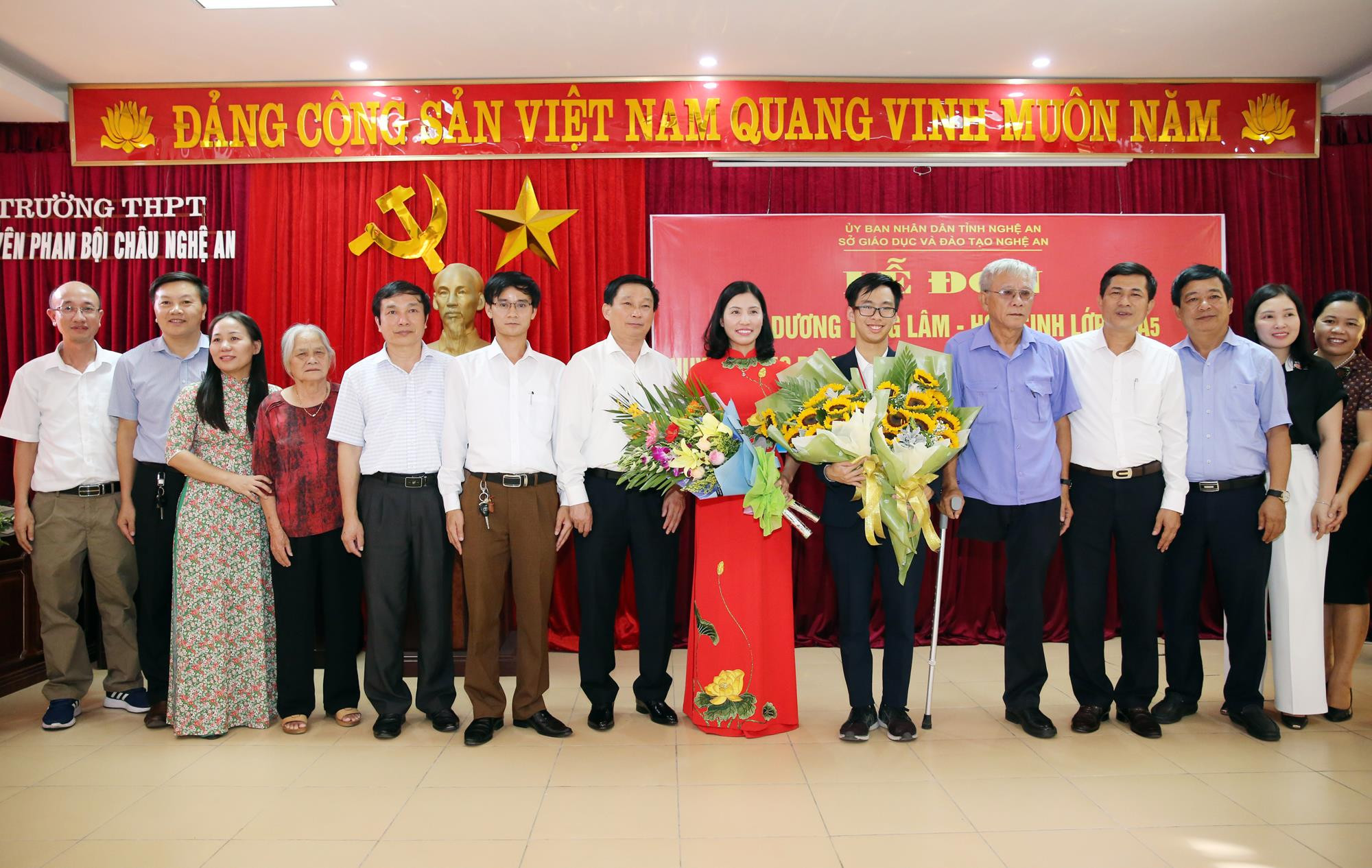 Giám đốc Sở Giáo dục và Đào tạo tặng hoa chúc mừng tập thể học sinh, giáo viên Trường THPT chuyên Phan Bội Châu và gia đình em Dương Tùng Lâm. Ảnh: Đức Anh.