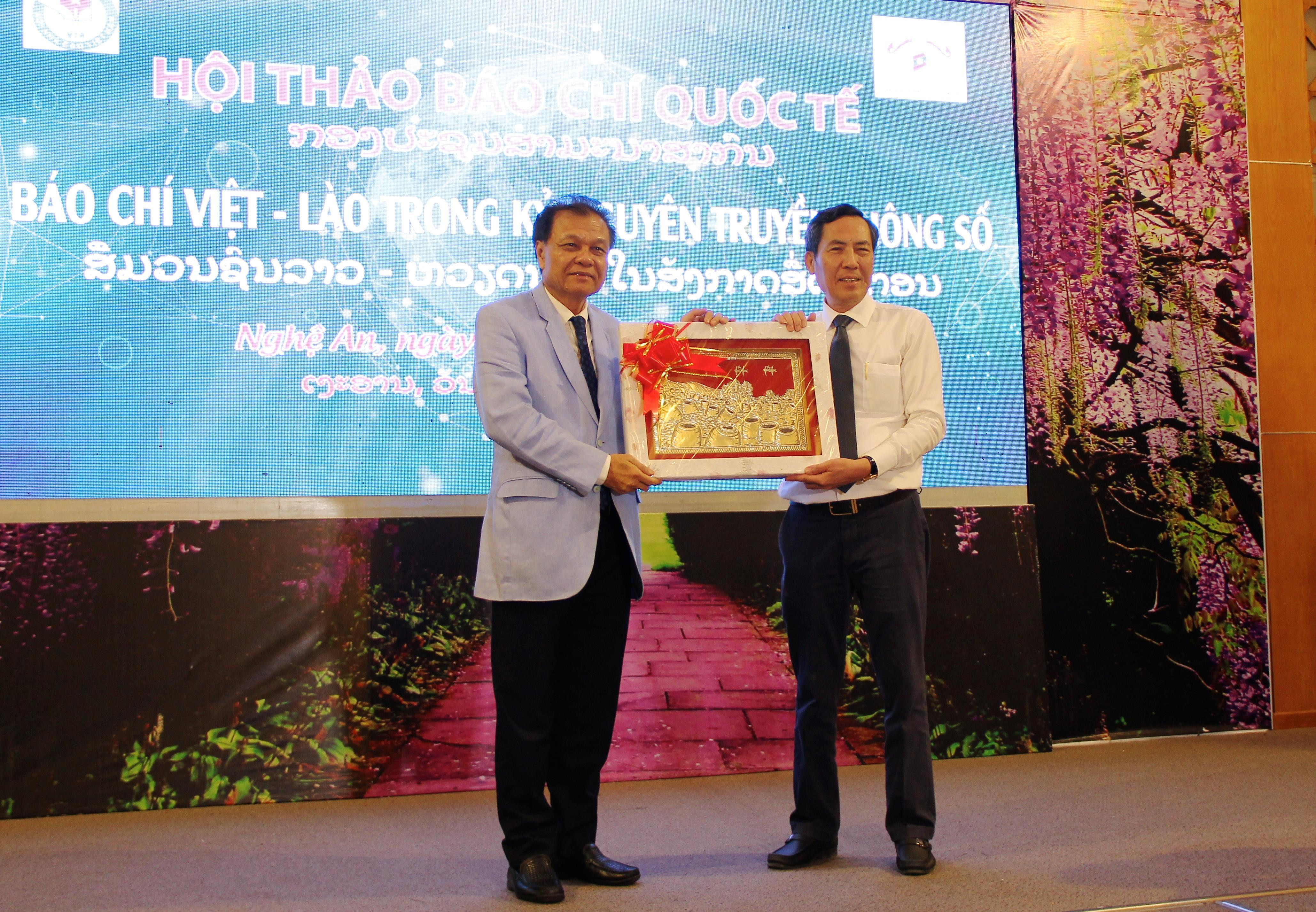 Chủ tịch Hội Nhà báo Việt Nam (bên phải) trao tặng quà cho Chủ tịch Hội Nhà báo Lào. Ảnh: Mỹ Nga 