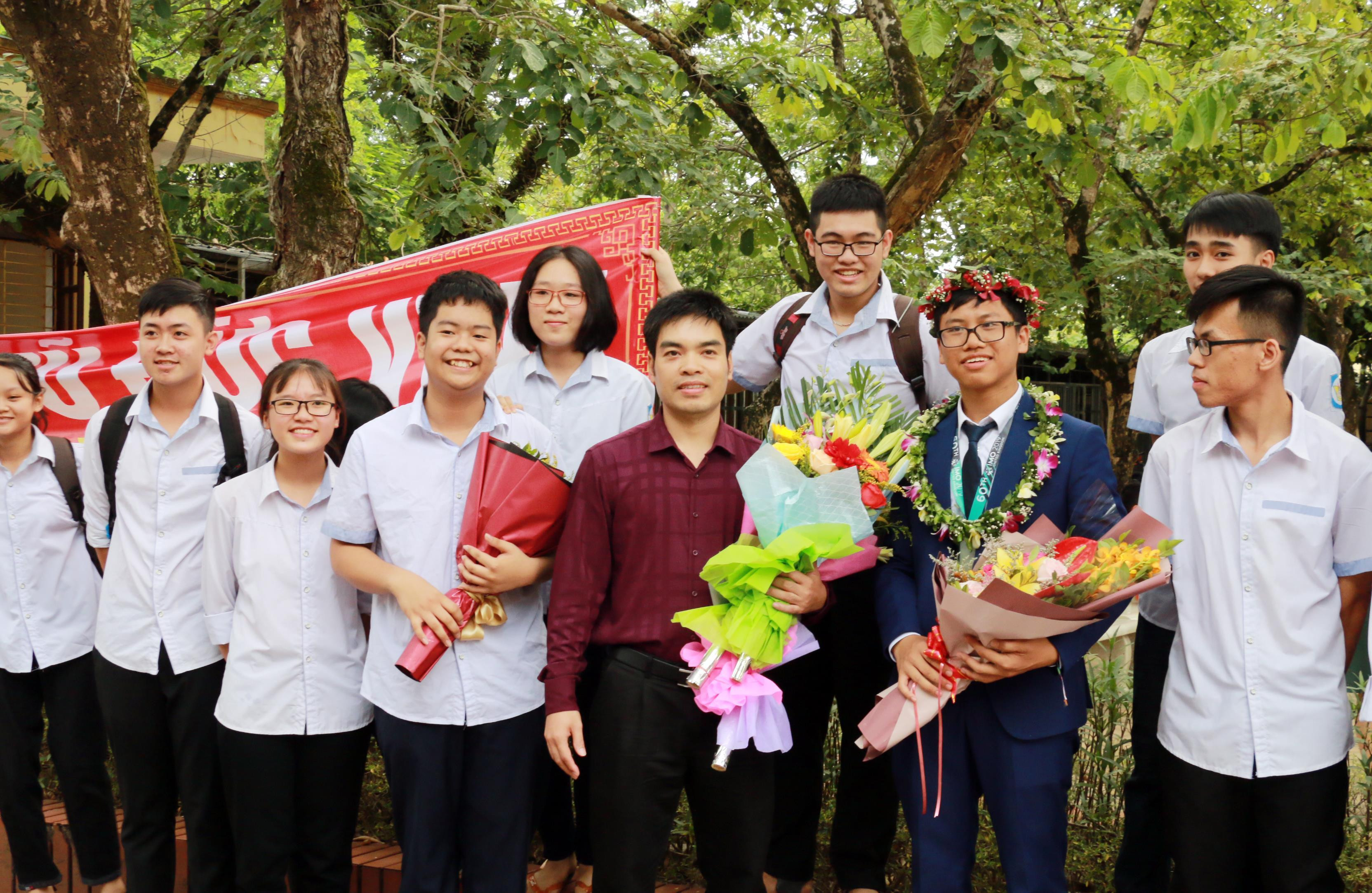 Thầy giáo Hồ Sỹ Hùng cùng với học trò tại lễ đón được tổ chức tại Trường THPT chuyên Phan Bội Châu. Ảnh: Mỹ Hà