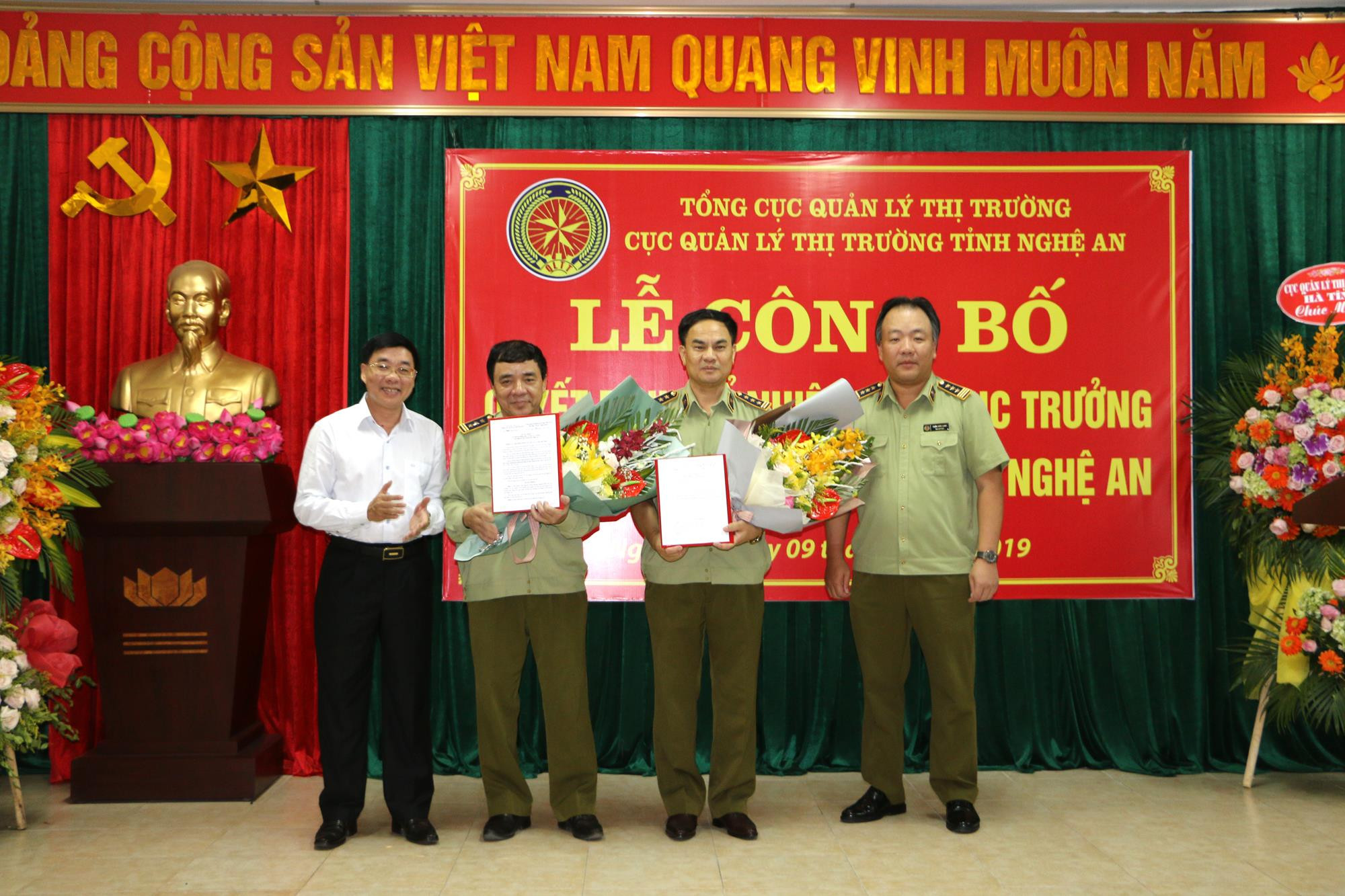 Lãnh đạo Tổng Cục quản lý thị trường và Tỉnh ủy Nghệ An trao Quyết định bổ nhiệm và tặng hoa chúc mừng cho 2 Cục phó Cục quản lý thị trường. Ảnh: Nguyễn Hải