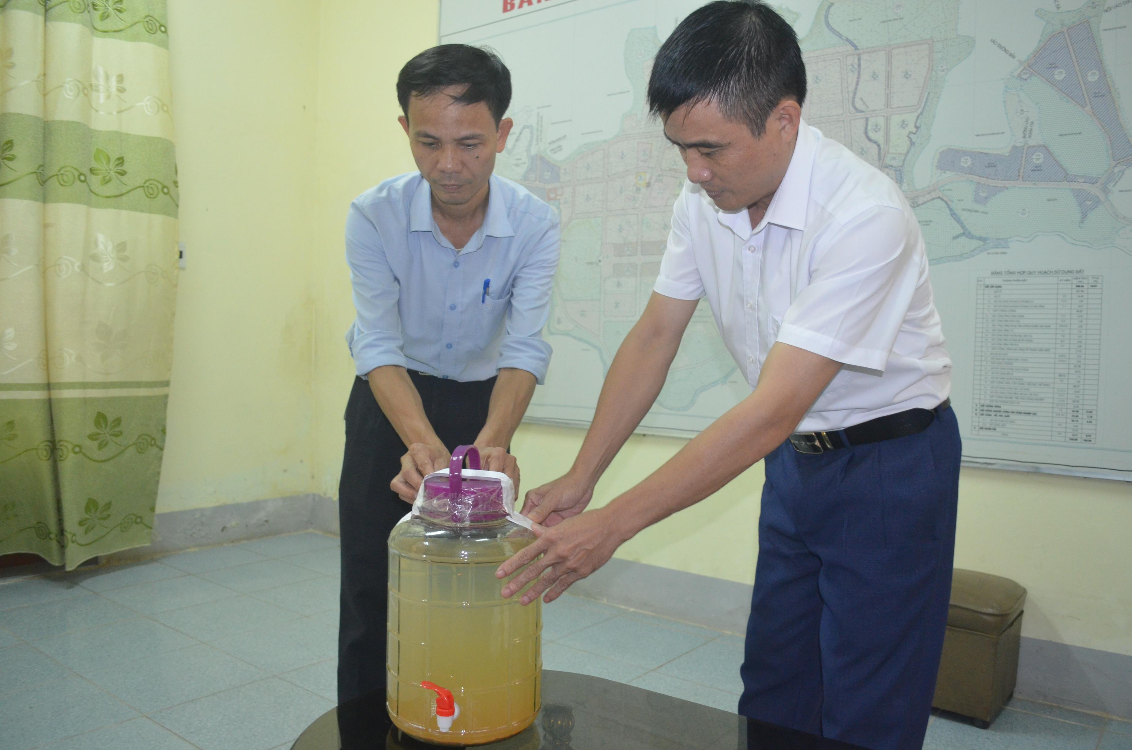 Cán bộ UBND thị trấn Quỳ Hợp niêm phong mẫu nước suối Nậm Huống để đưa đi kiểm nghiệm.