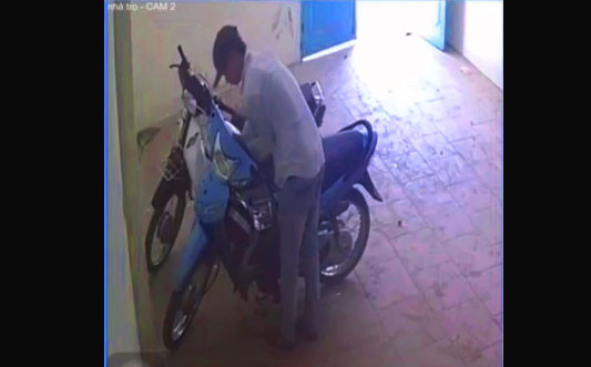 Một nam thanh niên đang bẻ khóa xe máy - Ảnh trích xuất từ camera an ninh