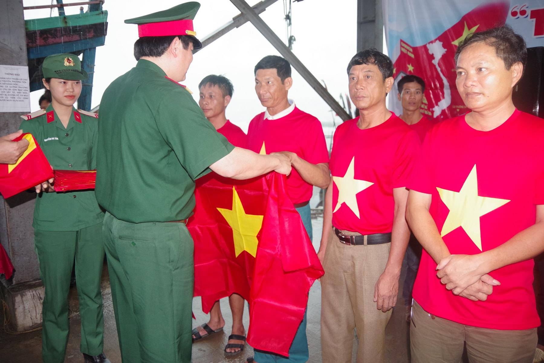Thượng tá Thái Đức Hạnh trao cờ Tổ quốc cho đại diện các ngư dân trên địa bàn thị xã Hoàng Mai