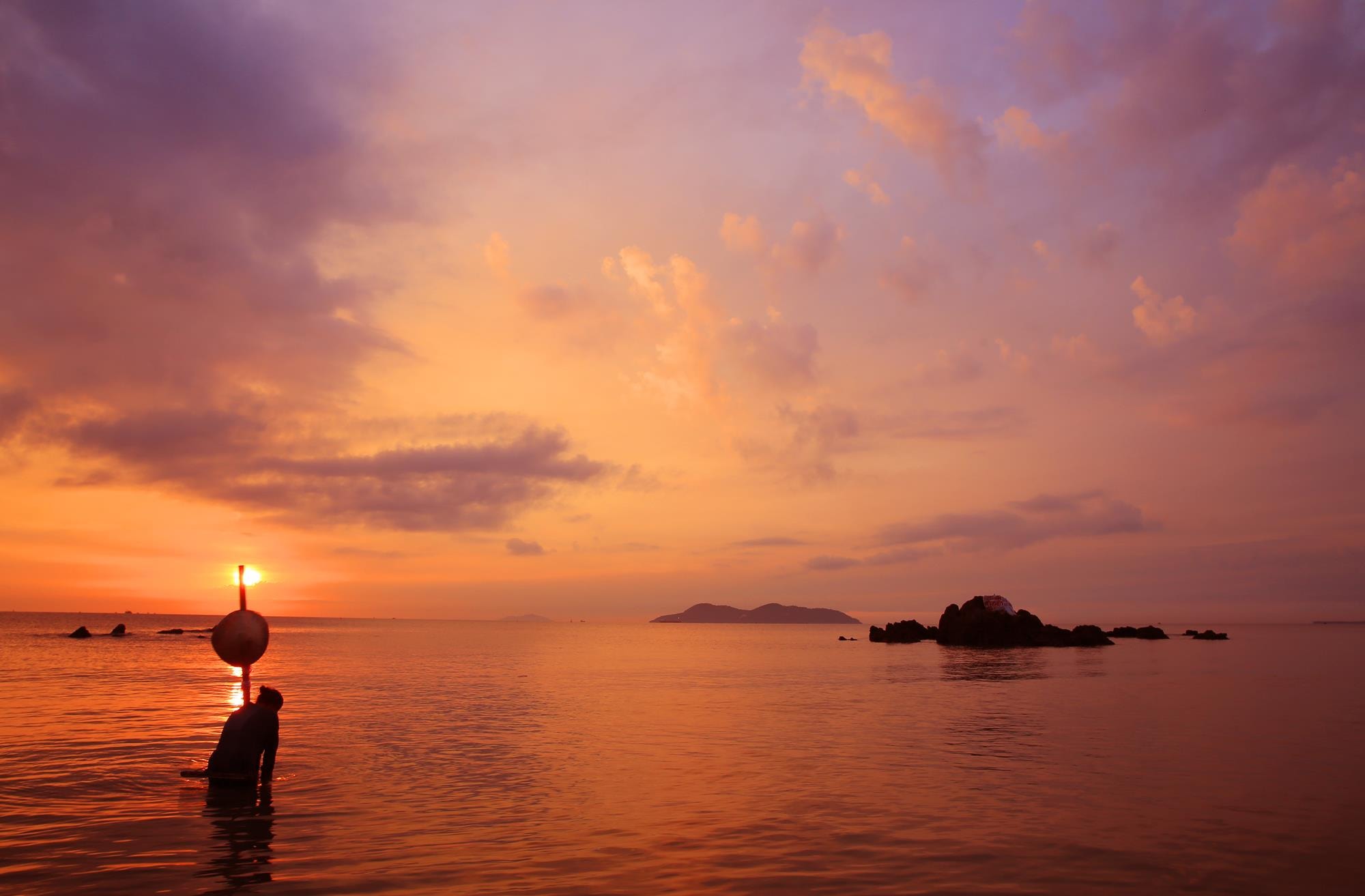 Bên bờ biển, những người phụ nữ trung tuổi mải miết với nghề cào hến, cào ngao của mình. Ảnh: Hồ Phương