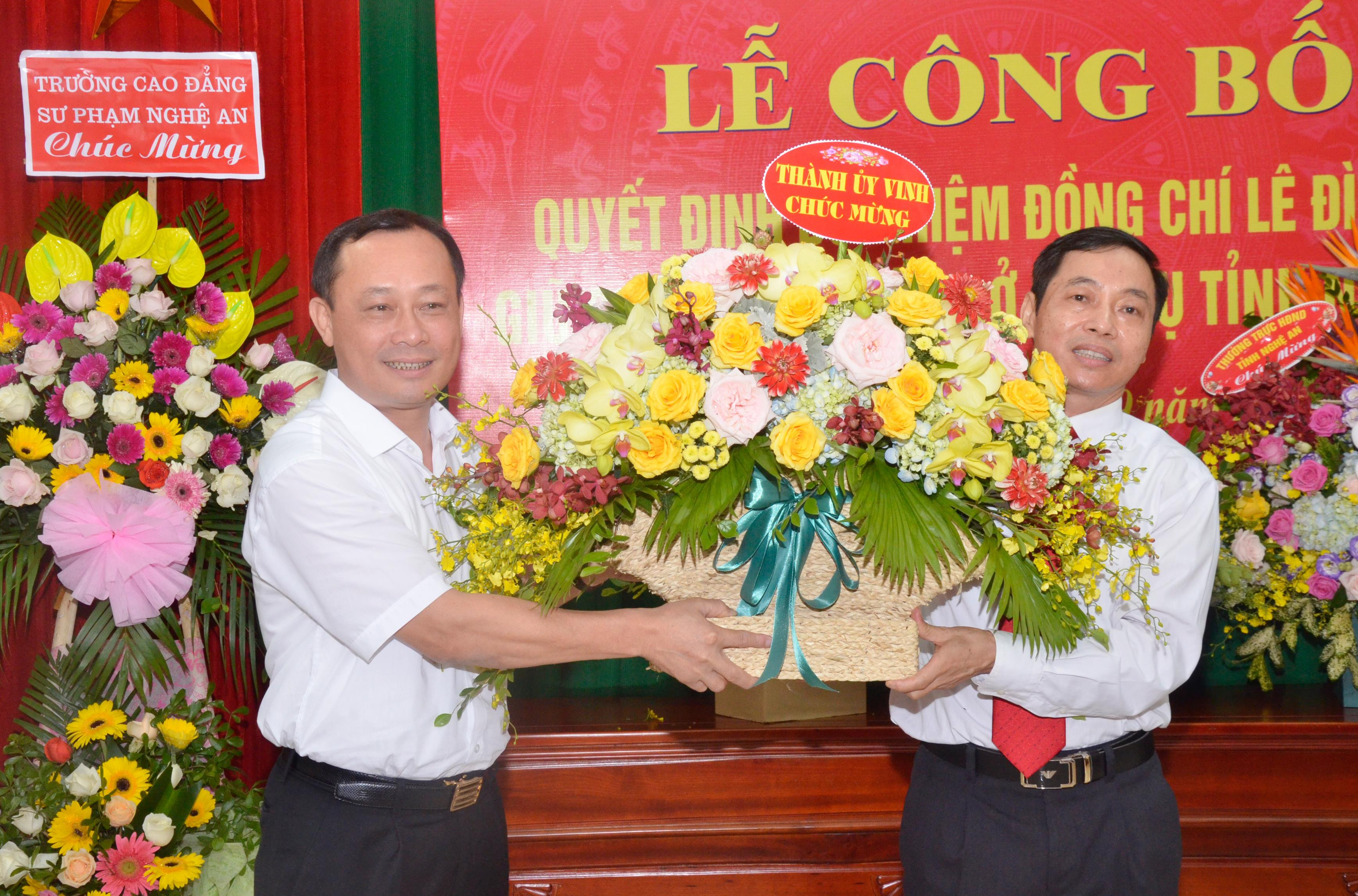 Bí thư Thành ủy Vinh Phan Đức Đồng tặng hoa chúc mừng đồng chí Lê Đình Lý. Ảnh: Thanh Lê