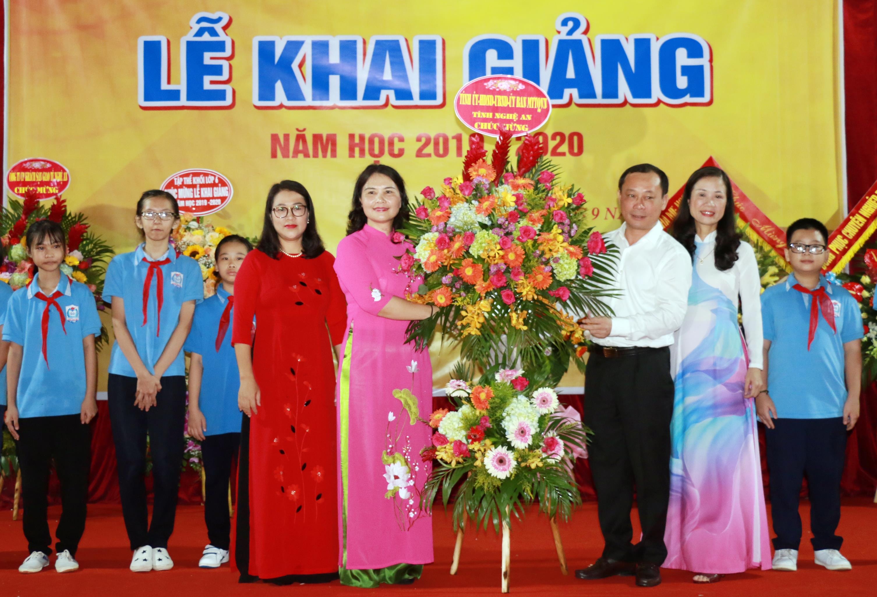 Bí thư Thành ủy Vinh tặng hoa chúc mừng năm học mới cho tập thể nhà trường. Ảnh: Mỹ Hà.