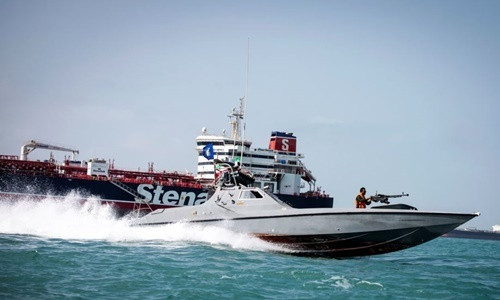 Tàu cao tốc Iran lướt qua tàu chở dầu Stena Impero mang cờ Anh hồi tháng trước. Ảnh: Reuters.