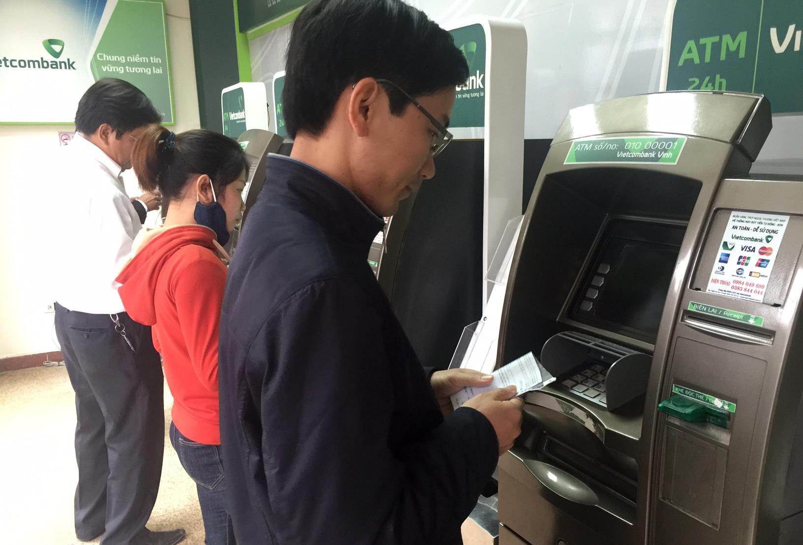 Người dân thành phố rút tiền tại cây ATM. Ảnh: Thu Huyền