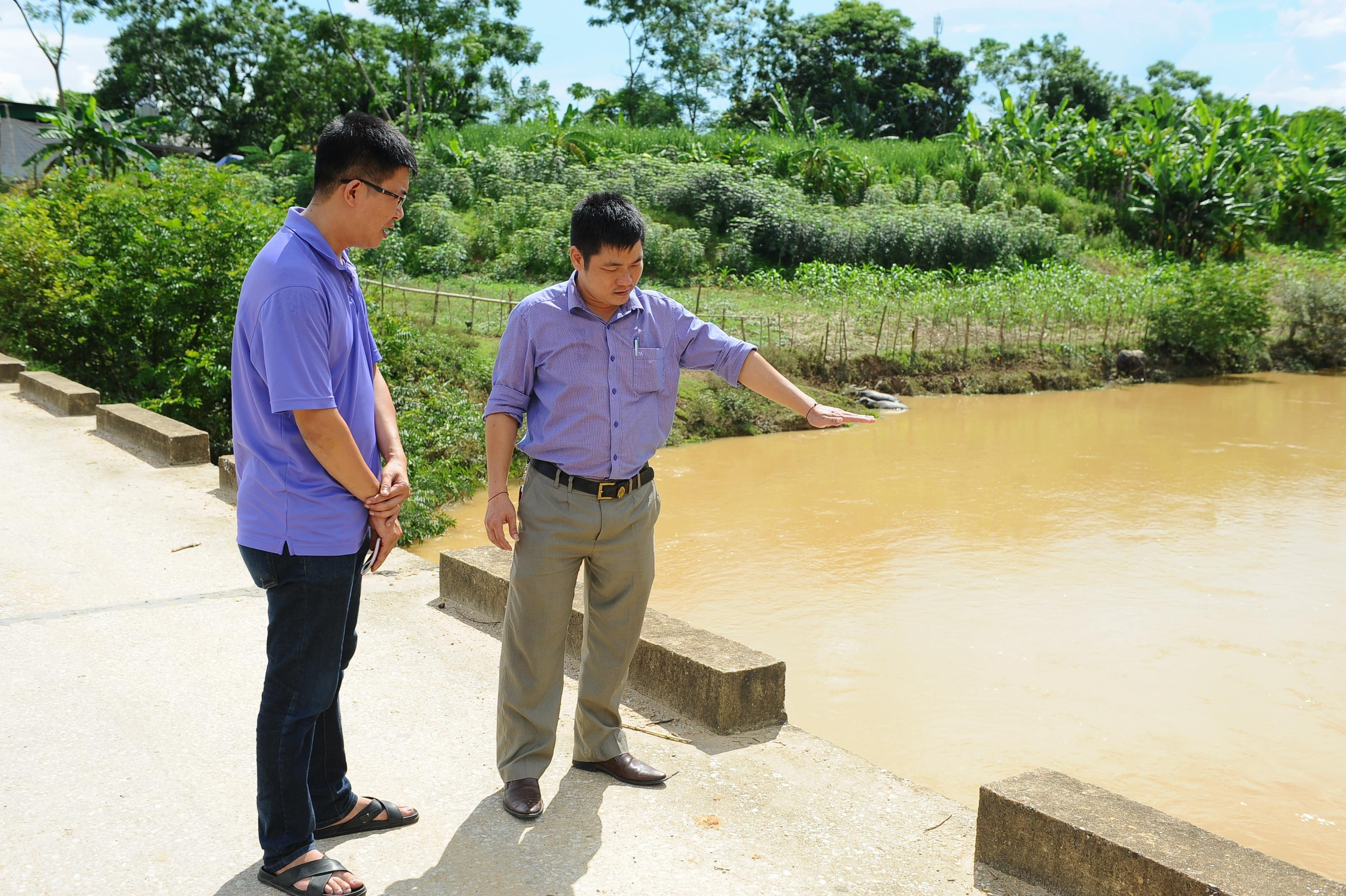 Ông Nguyễn Văn Dũng, chủ tịch UBND xã Châu Thắng diễn tả về mức nước vượt tràn trong đợt xả lũ ngày 03 tháng 8 vừa qua. Ảnh: Thành Cường