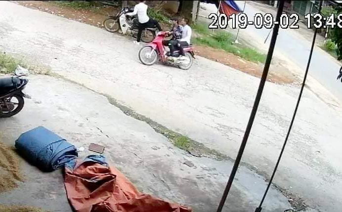 Hình ảnh 2 thanh niên mặc đi trên xe máy màu đỏ được camera ghi lại. Ảnh công an cung cấp