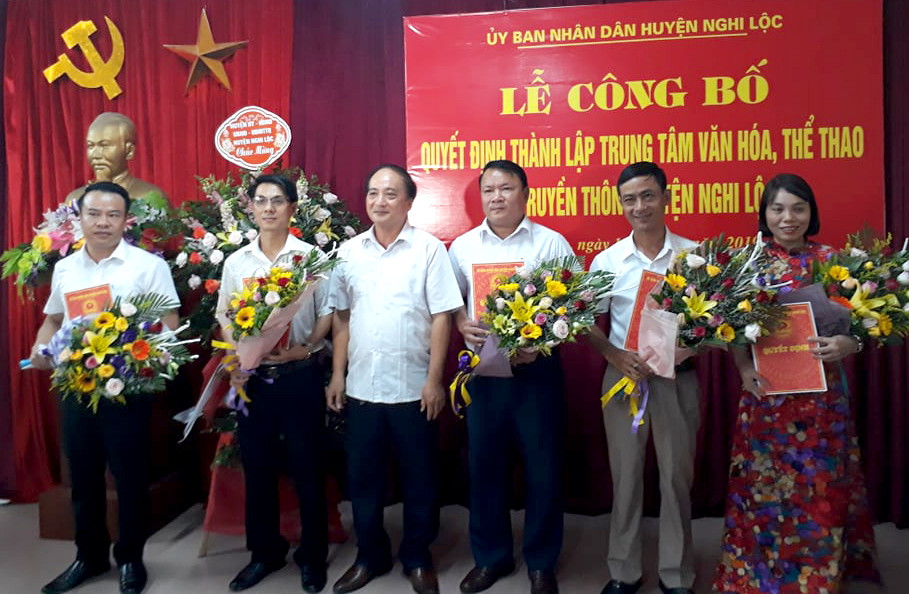 Lãnh đạo huyện Nghi Lộc trao các quyết định cho giám đốc và 4 phó giám đốc Trung tâm Văn hóa - Thể thao và Truyền thông huyện Nghi Lộc. Ảnh: Thành Duy