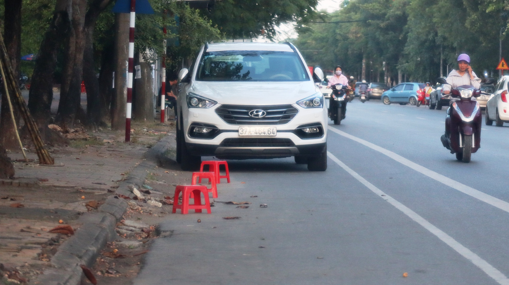 Trên đường Phan Đăng Lưu thuộc phường Trường Thi ( TP Vinh) vẫn còn tình trạng người dân đặt cả dãy ghế nhựa để ngăn xe hơi dừng, đậu trước quán hàng. Ảnh: Khánh An ( ảnh chụp chiều ngày 12/9)