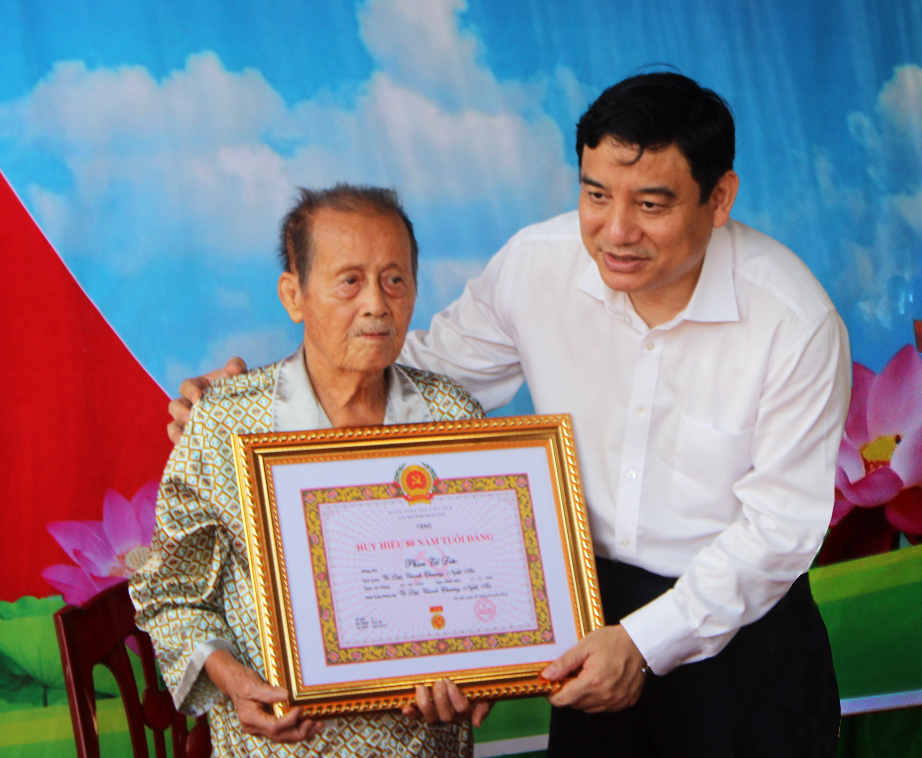 Bí thư Tỉnh ủy Nguyễn Đắc Vinh trao tặng Huy hiệu 80 tuổi Đảng cho đảng viên Phan Tố Đức. Ảnh Nguyễn Trung Thành