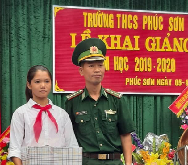 Thượng úy Lê Anh Tuấn tặng quà cho em Thương nhân dịp khai giảng năm học mới