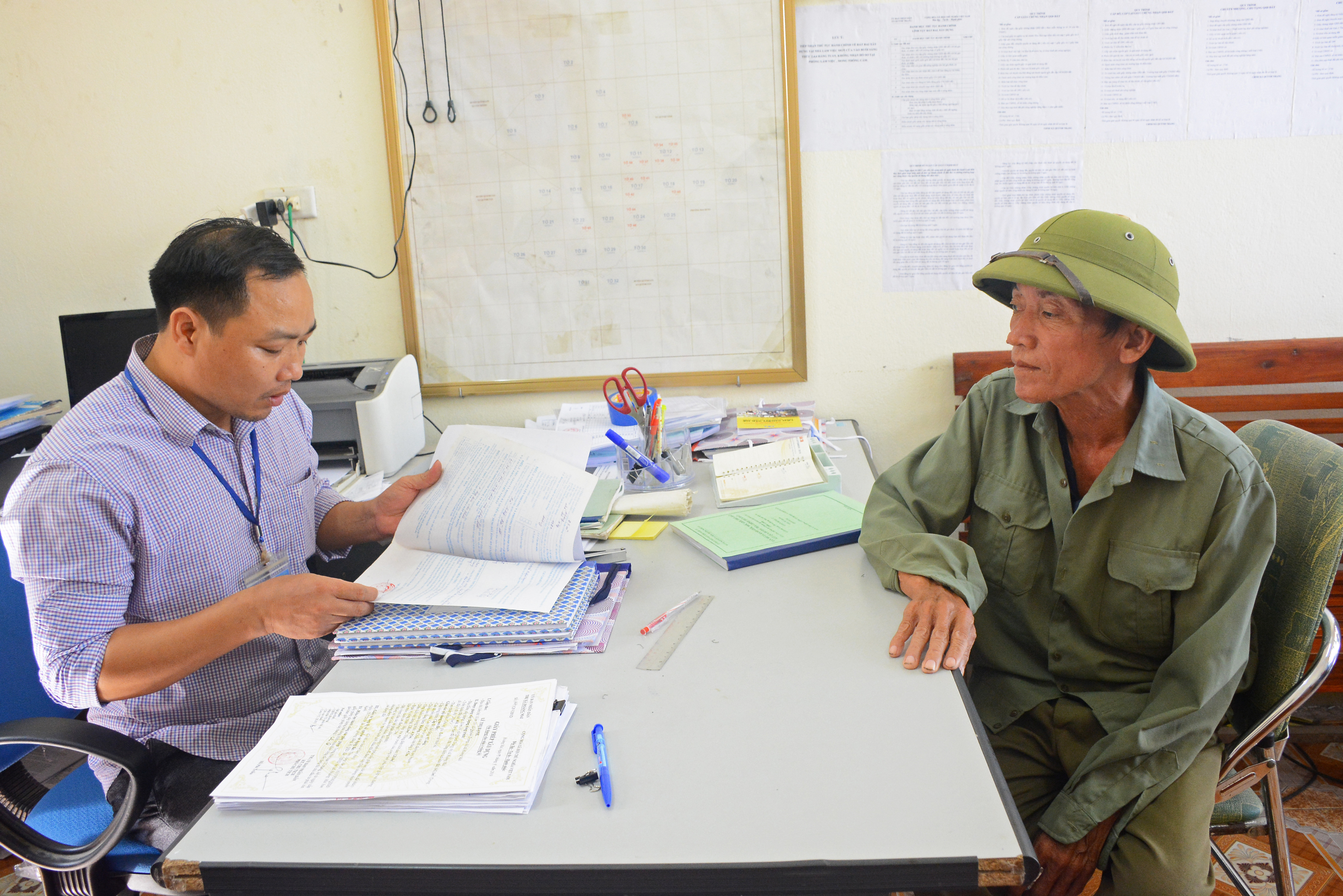 Hướng dẫn người dân giải quyết thủ tục hành chính tại Bộ phận Một cửa xã Quỳnh Trang, thị xã Hoàng Mai. Ảnh: Thu Giang