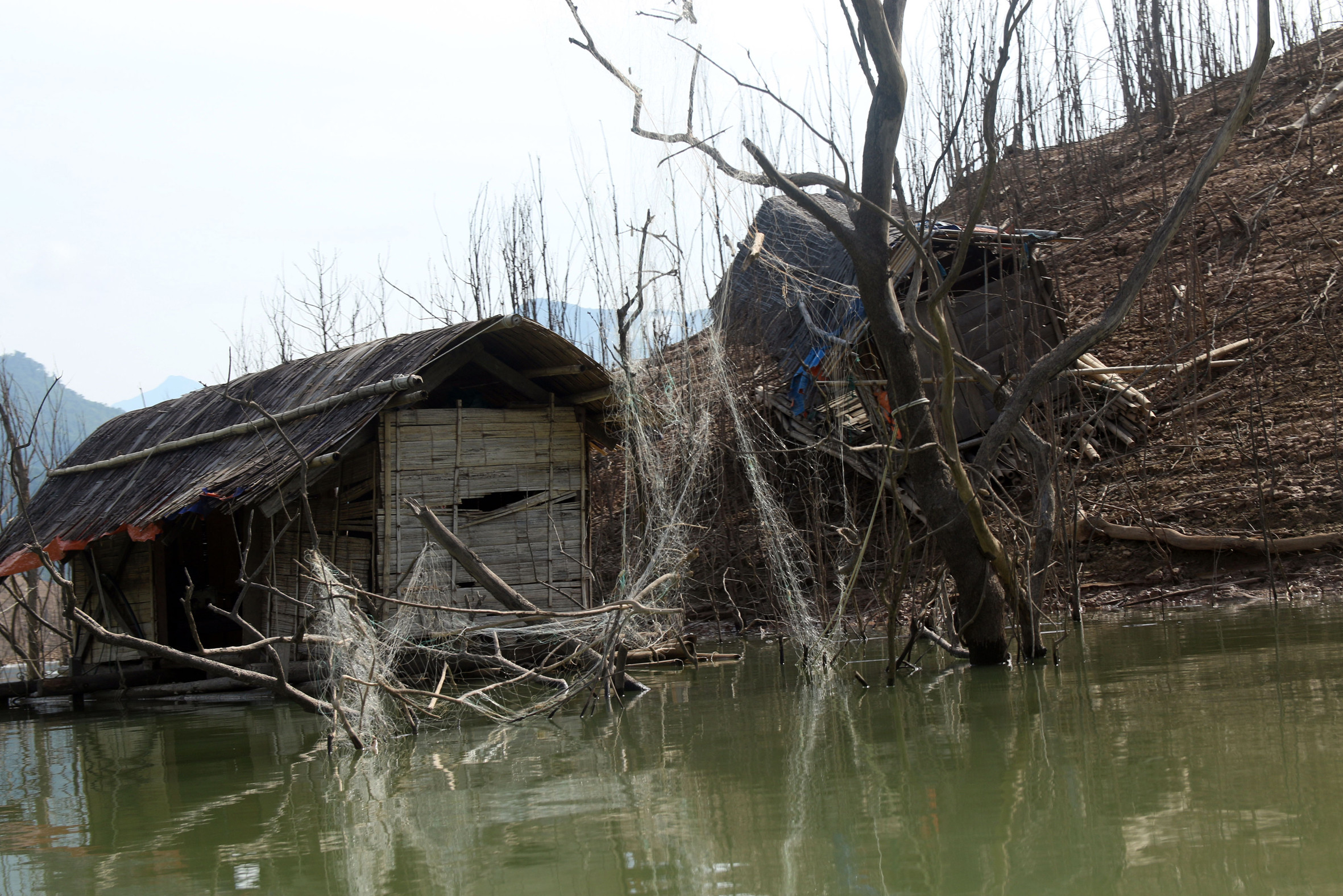 Những chiếc nhà bè dùng để ở đánh cá nay bị bỏ hoang hoặc nằm gác lại bên mép sông.