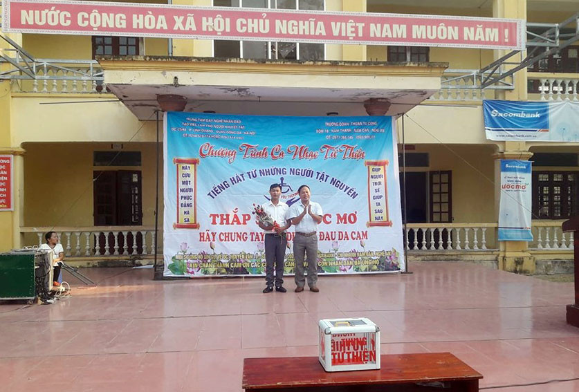 Lãnh đạo Trường THPT Phan Thúc Trực khen thưởng cho thầy giáo Đồng Văn Nhân. Ảnh: PV.