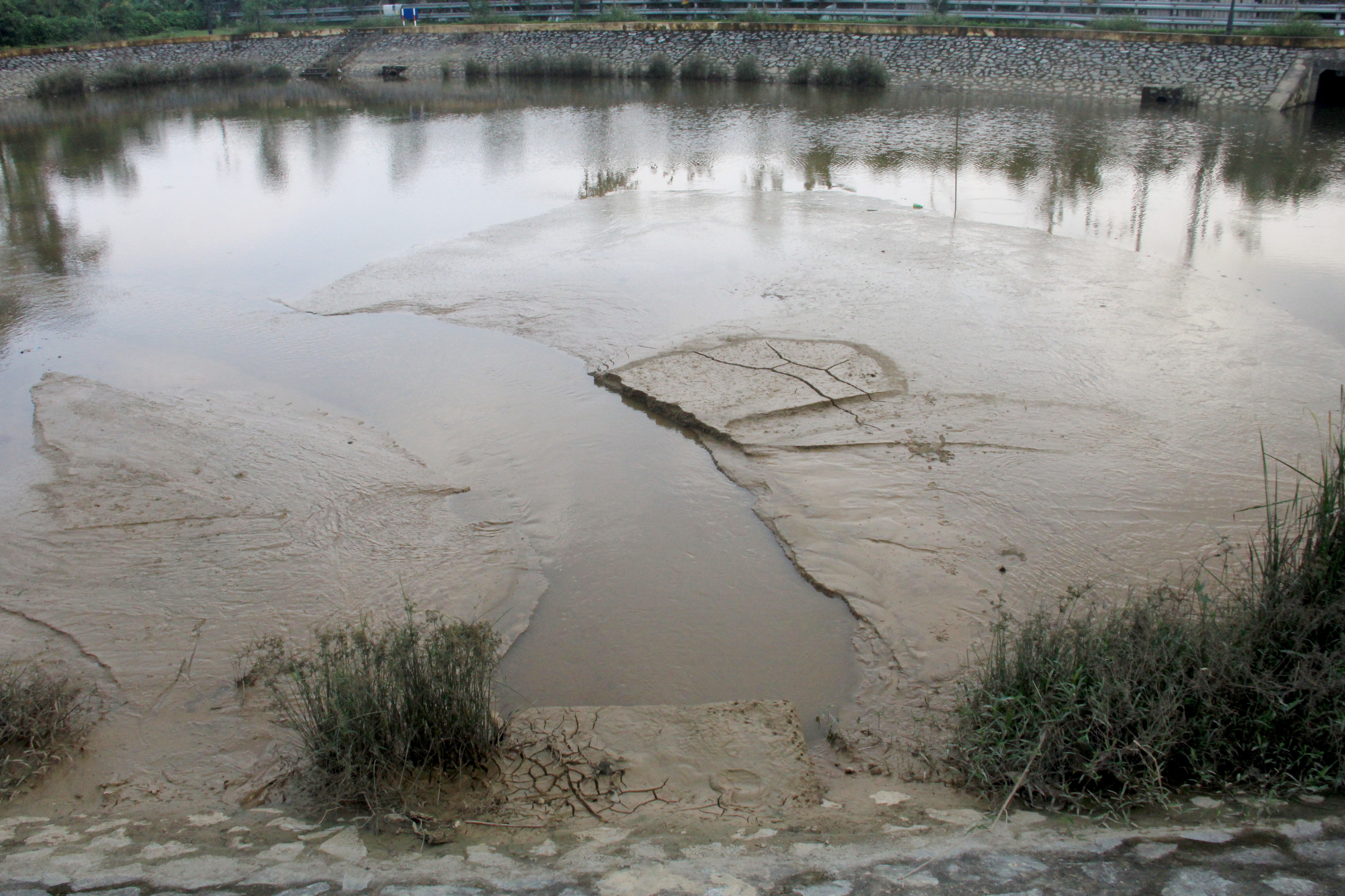 Vị trí đường ống thông từ hồ lắng của Công ty cấp nước Nghệ An chảy ra hồ điều hòa Cửa Nam. Ảnh: P.B