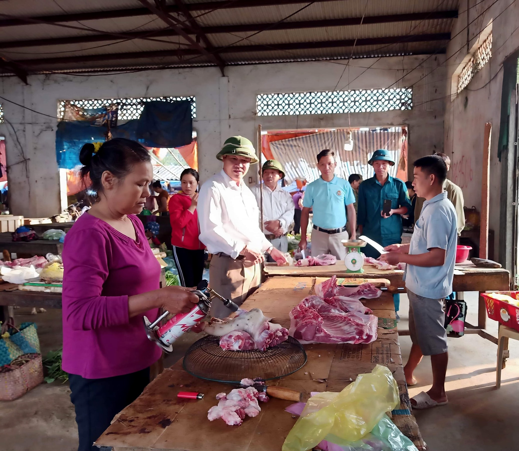 Lực lượng chức năng kiểm tra, tuyên truyền các tiểu thương ở các chợ về kinh doanh thịt lợn an toàn trong thời điểm dịch tả bùng phát phức tạp. Ảnh: Thanh Phúc