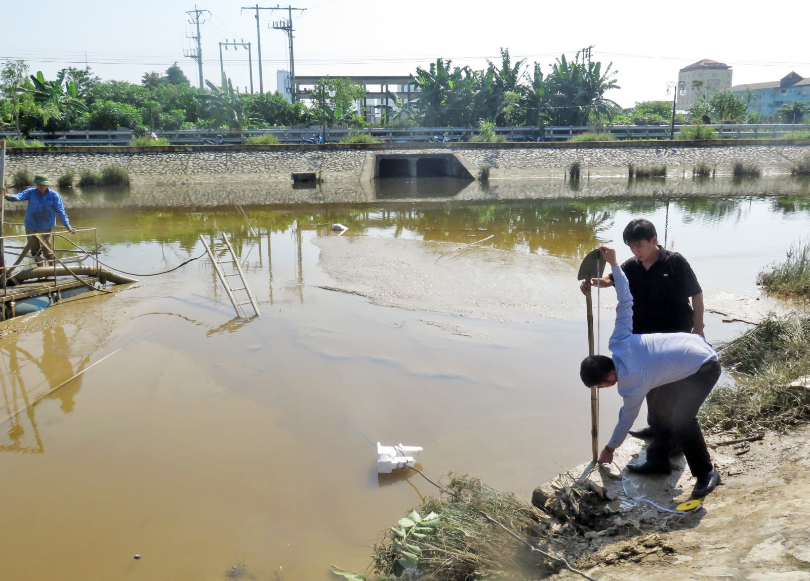 PV Báo Nghệ An cùng cán bộ trật tự đô thị phường Cửa Nam đo độ sâu của chiếc cống ngầm xả bùn thải. Ảnh: Hà Giang