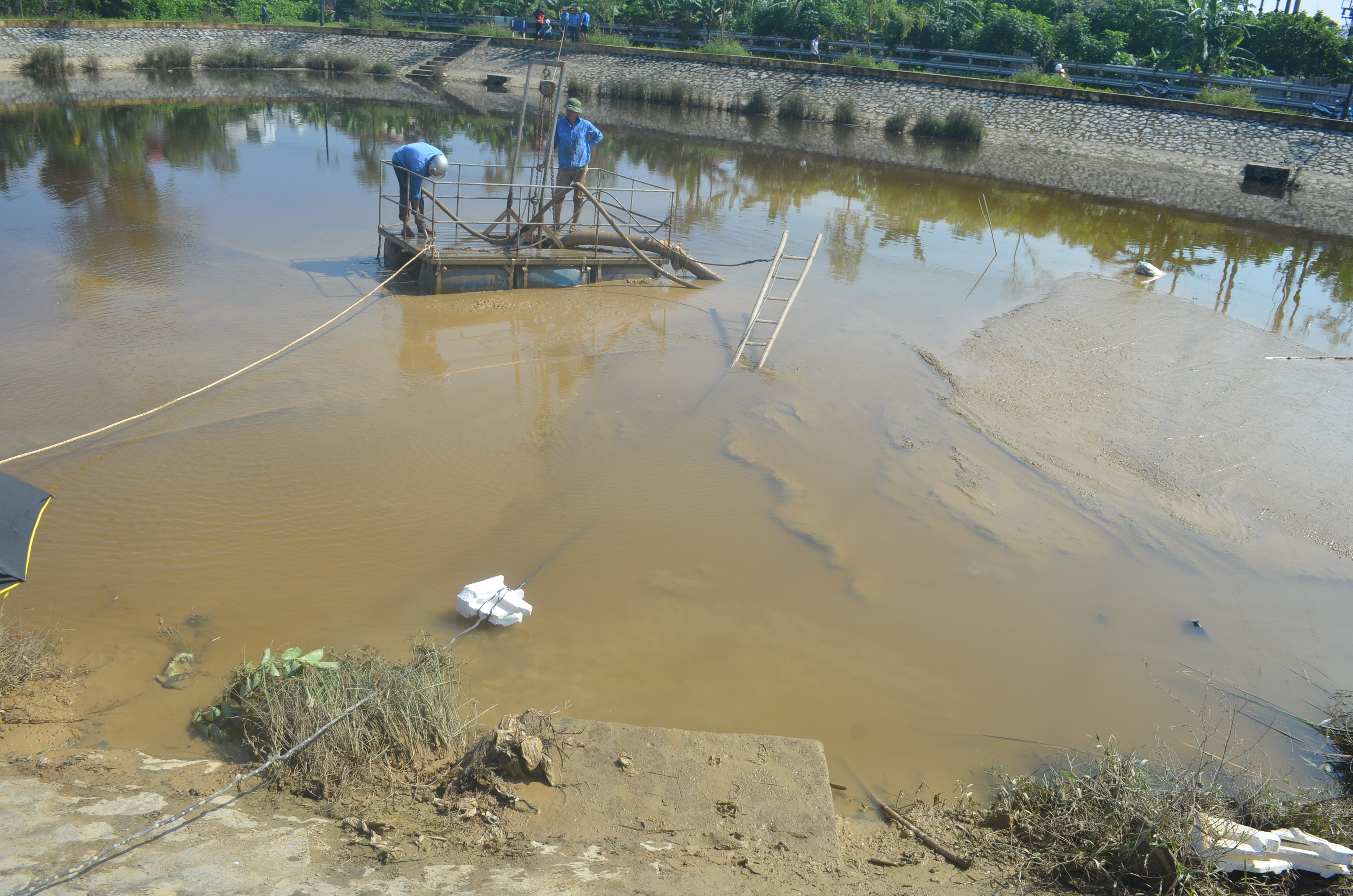 Cống ngầm từ hệ thống hố lắng của Nhà máy nước Hưng Vĩnh xả bùn thải vào hồ điều hòa Cửa Nam. Ảnh: Nhật Lân