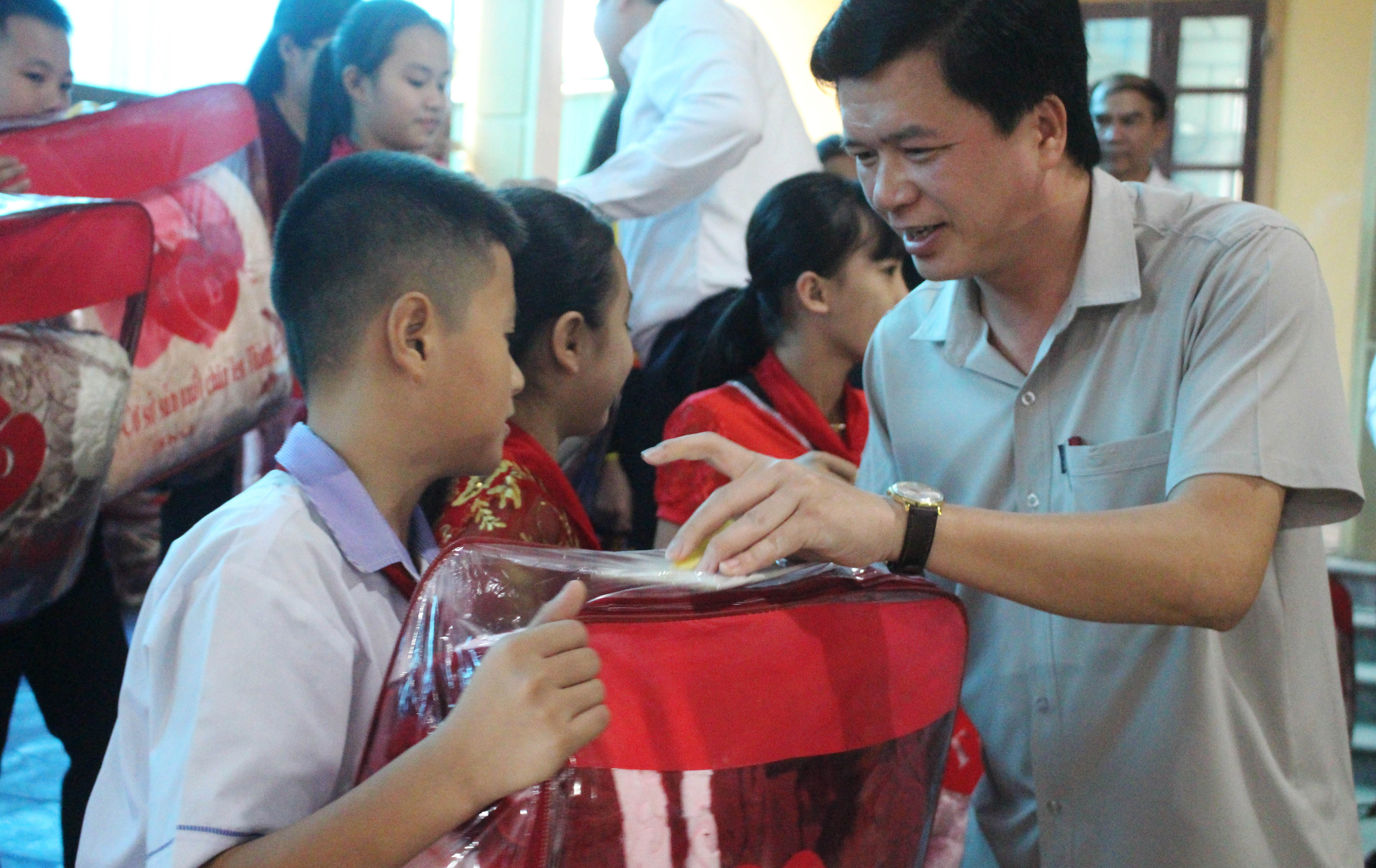 Bí thư Huyện ủy Con Cuông Nguyễn Đình Hùng trao quà của Phó Chủ tịch Quốc hội Tòng Thị Phóng đến với các em hoc sinh. Ảnh: Bảo Hân 