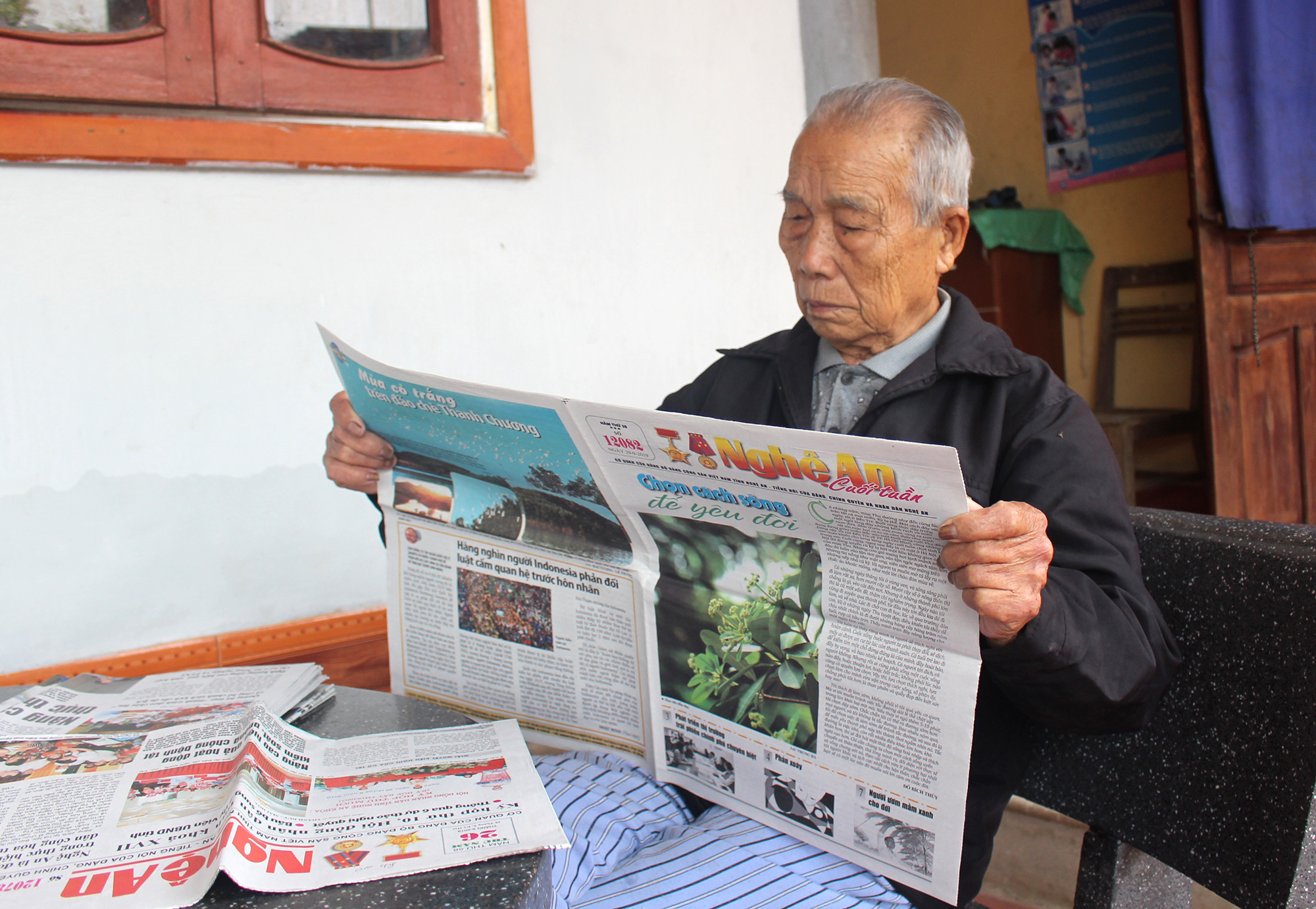 Đọc Báo Nghệ An là hoạt động quen thuộc vào mỗi buổi sáng của ông Nguyễn Quang Long, 80 tuổi, ở xã Thanh Tường, huyện Thanh Chương. Ảnh: Phước Anh