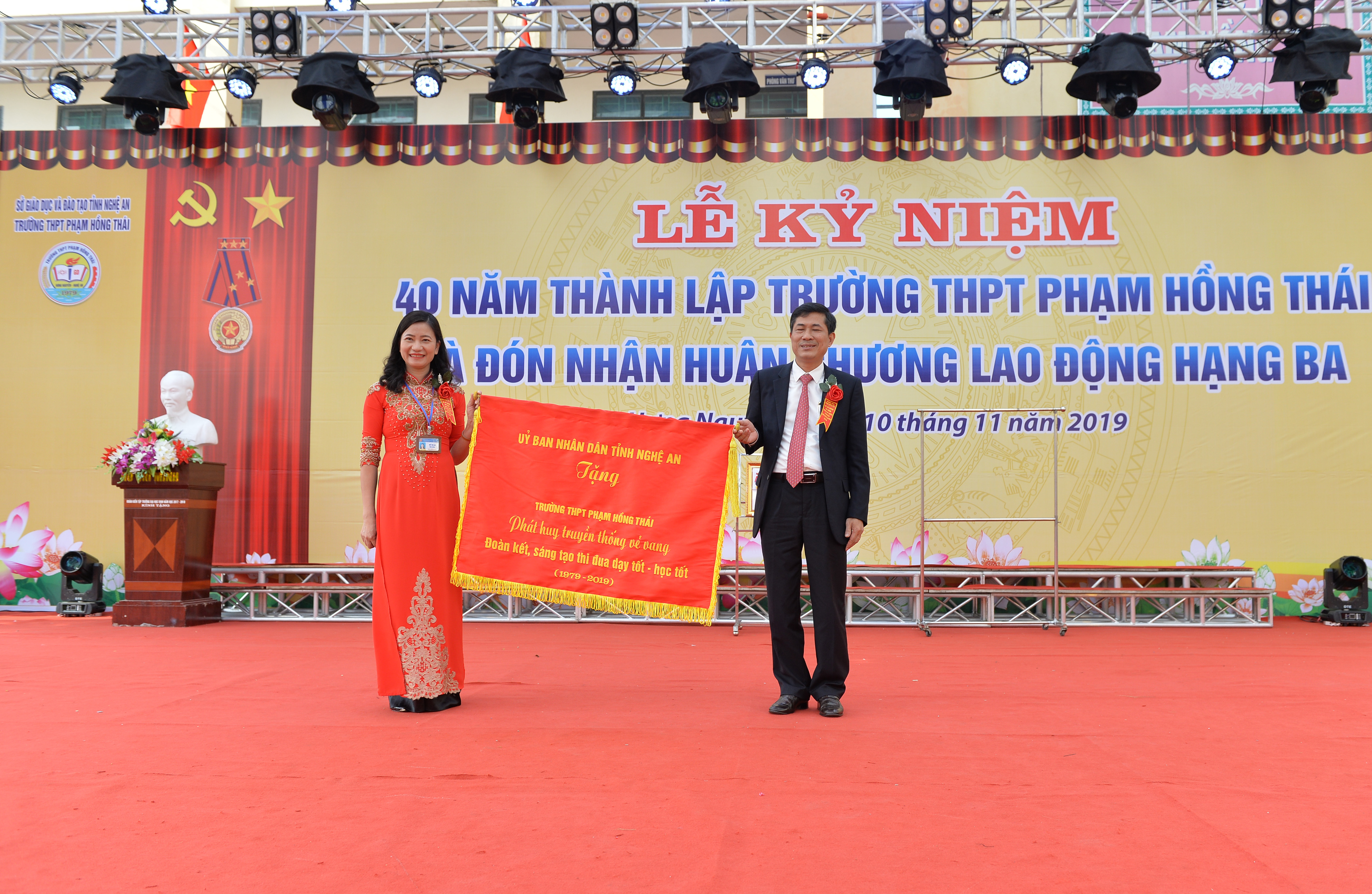 Đồng chí Thái Văn Thành trao bức trướng của UBND tỉnh cho lãnh đạo nhà trường. Ảnh: Thành Cường