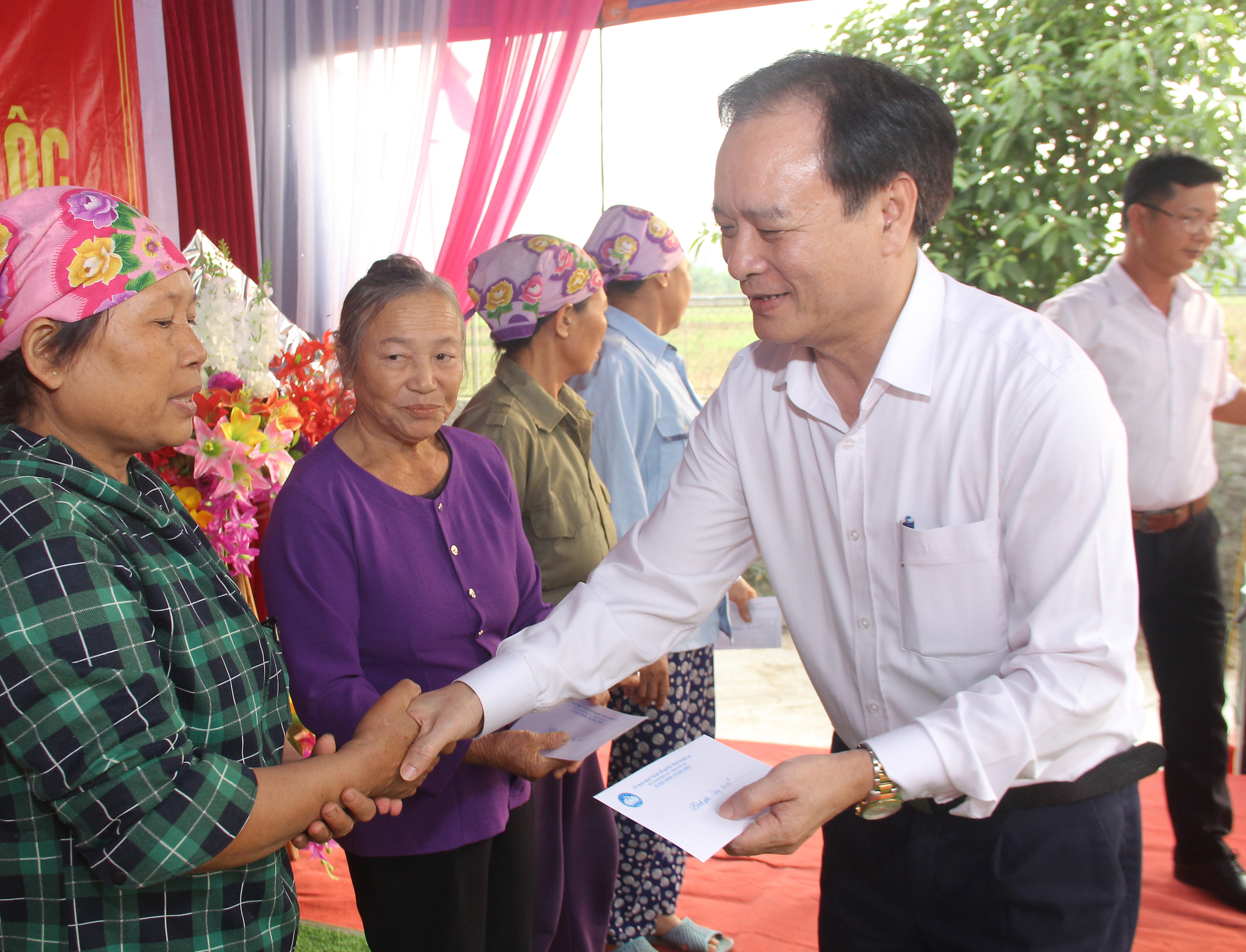 Đồng chí Hồ Phúc Hợp tặng quà cho các gia đình có hoàn cảnh khó khăn ở thon Cự Nậm. Ảnh: Mai Hoa