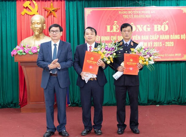 Đồng chí Võ Văn Dũng – Tỉnh ủy viên- Bí thư Thị ủy trao quyết định, tặng hoa chúc mừng Ảnh Tuấn Anh (Bí thư Đảng ủy Quỳnh Lộc)