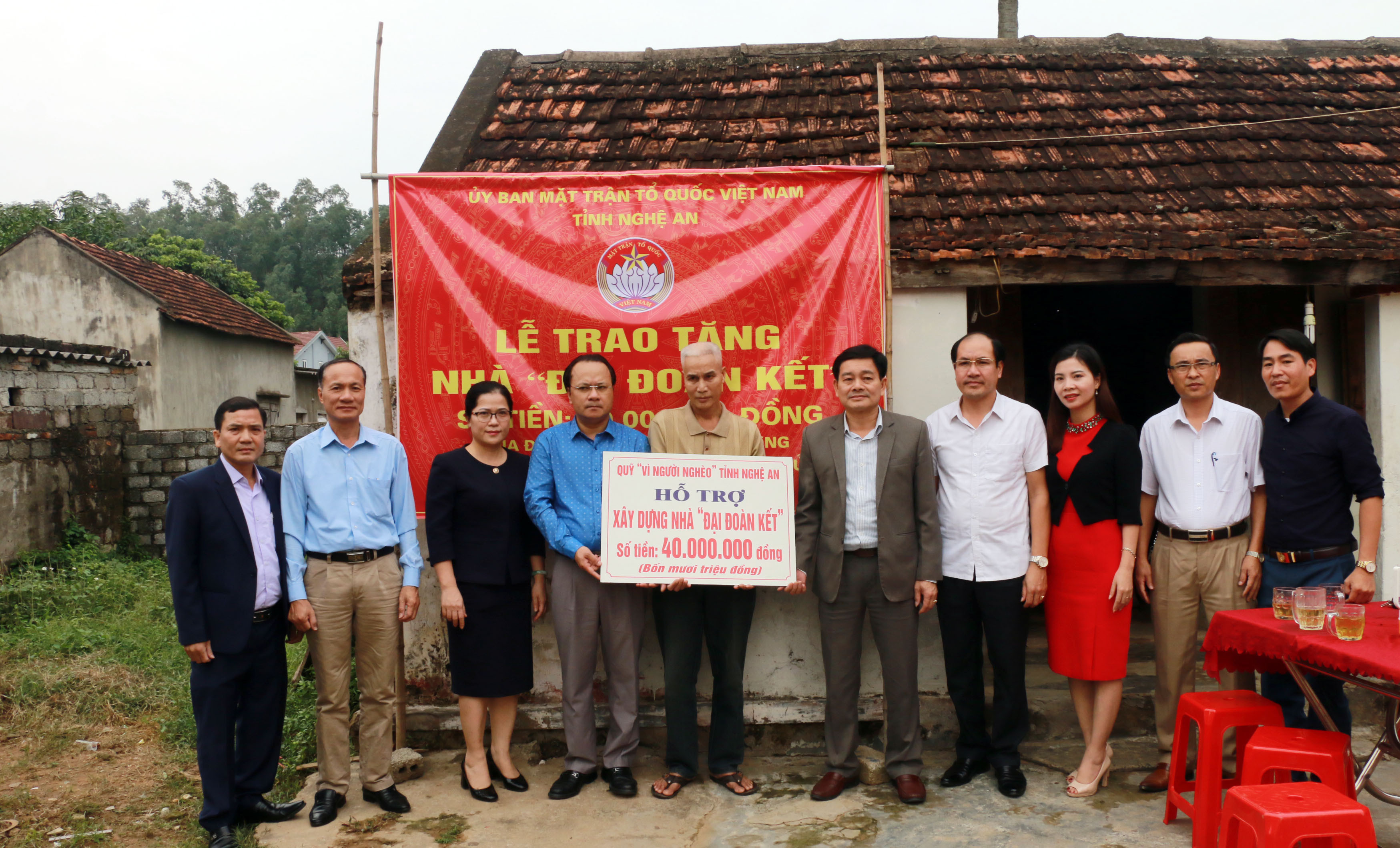 Đồng chí Nguyễn Nam Đình và các thành viên trong đoàn trao tặng hỗ trợ xây nhà Đại đoàn kết cho người dân phường Nghi Tân. Ảnh: Mỹ Hà