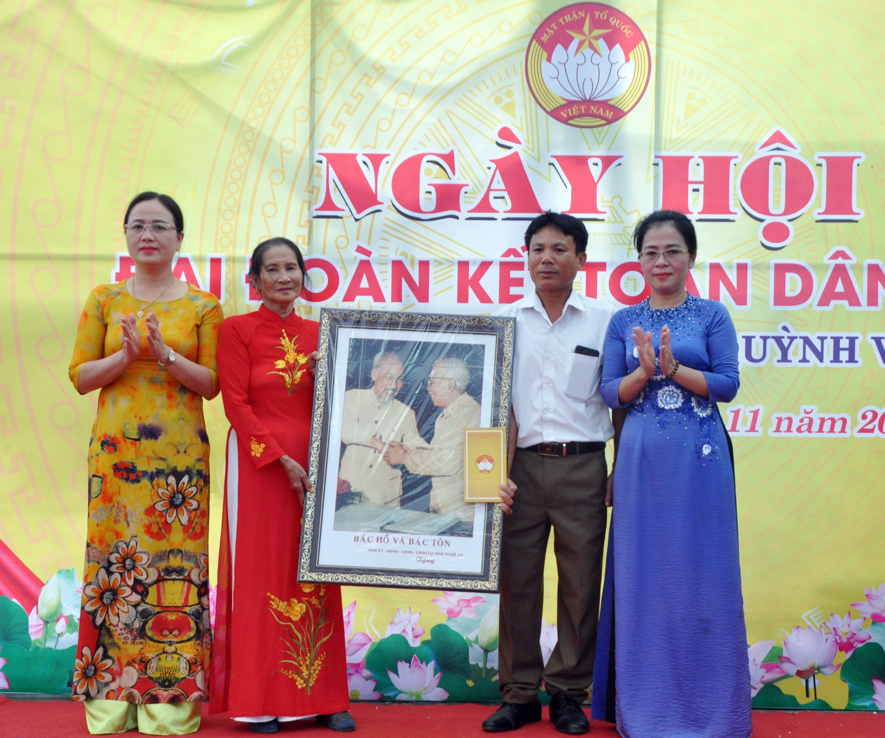 Đồng chí Võ Thị Minh Sinh trao bức ảnh “Bác Hồ với Bác Tôn” cho đại diện thôn 6.