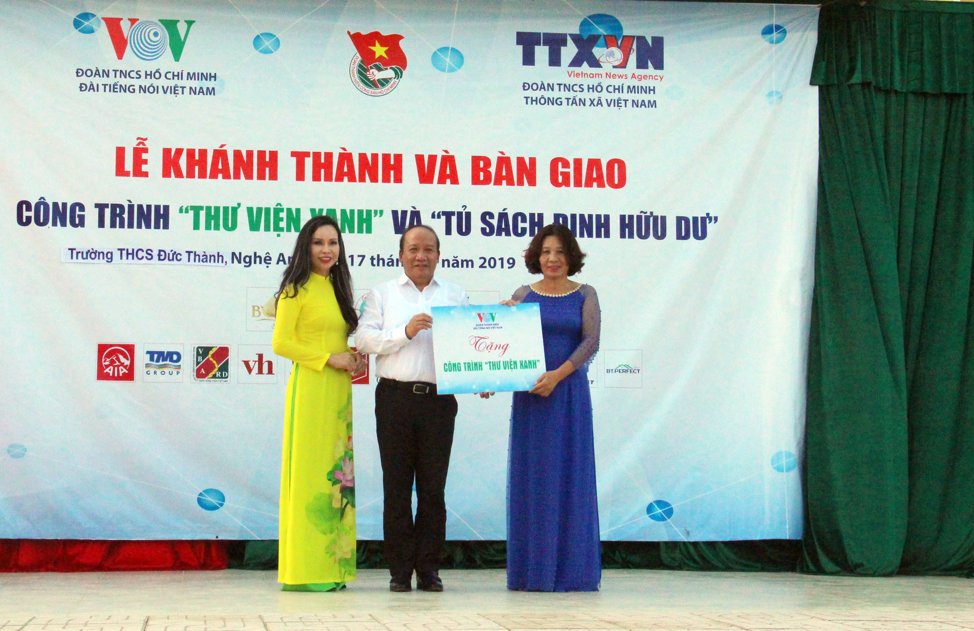Đại diện lãnh đạo Đài tiếng nói Việt Nam trao biển tượng trưng bàn giao công trình Thư viện Xanh cho trường THCS Đức Thành, đại diện Thông tấn xã Việt Nam trao tặng 1000 đầu sách. 