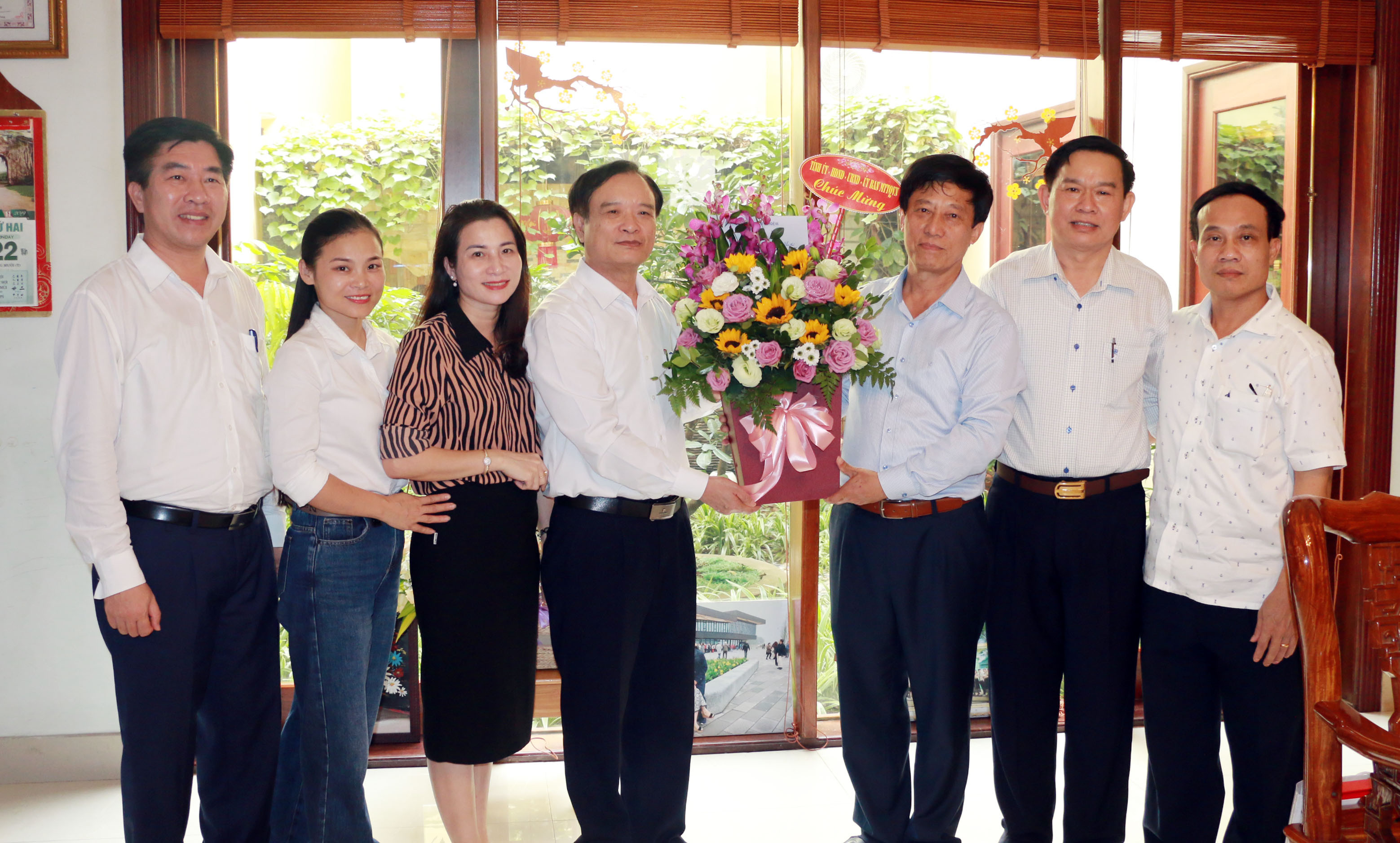 Đồng chi Hồ Phúc Hợp tặng hoa chúc mừng NGUT Nguyễn Duy Nam. Ảnh: Mỹ Hà